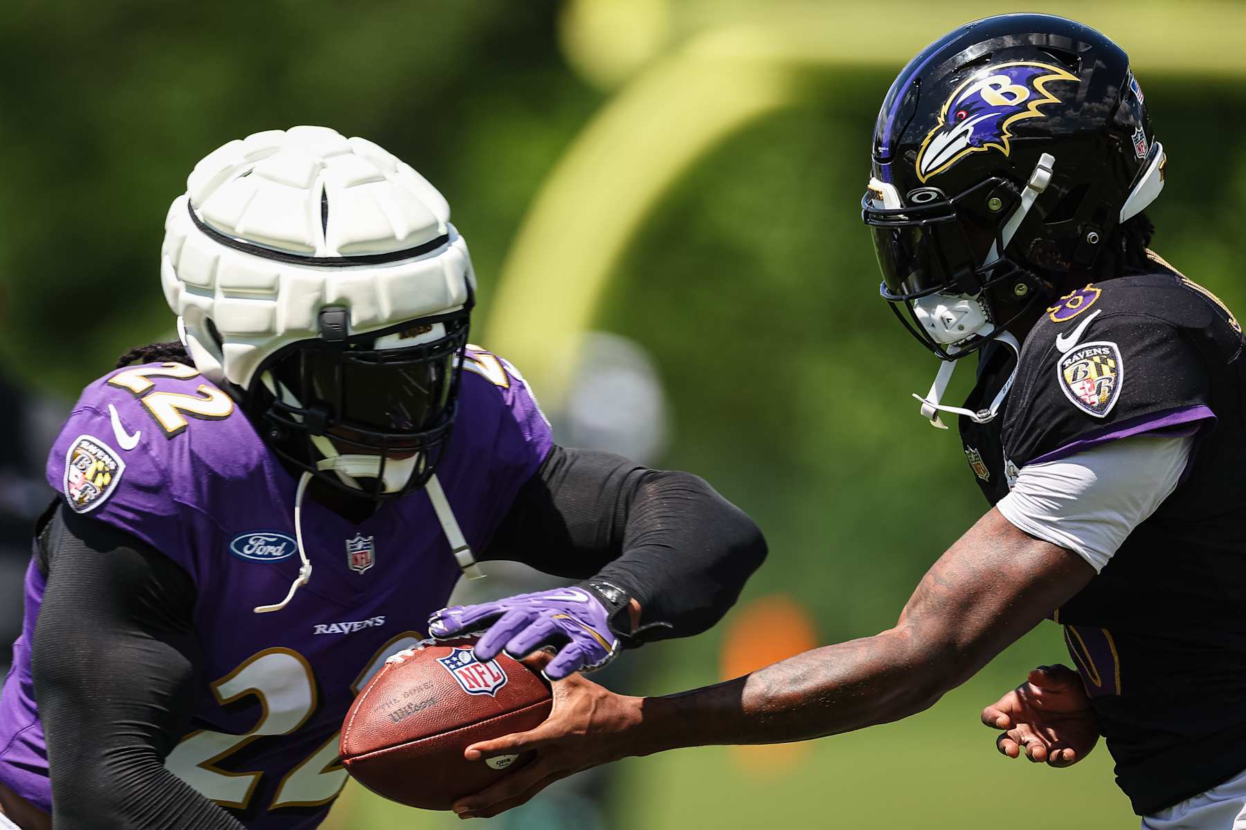 OWINGS MILLS, MD - AUGUST 12: Lamar Jackson #8 of the Baltimore Ravens hands the ball off to Derrick Henry #22 during training camp at Under Armour Performance Center Baltimore Ravens on August 12, 2024 in Owings Mills, Maryland. (Photo by Scott Taetsch/Getty Images)