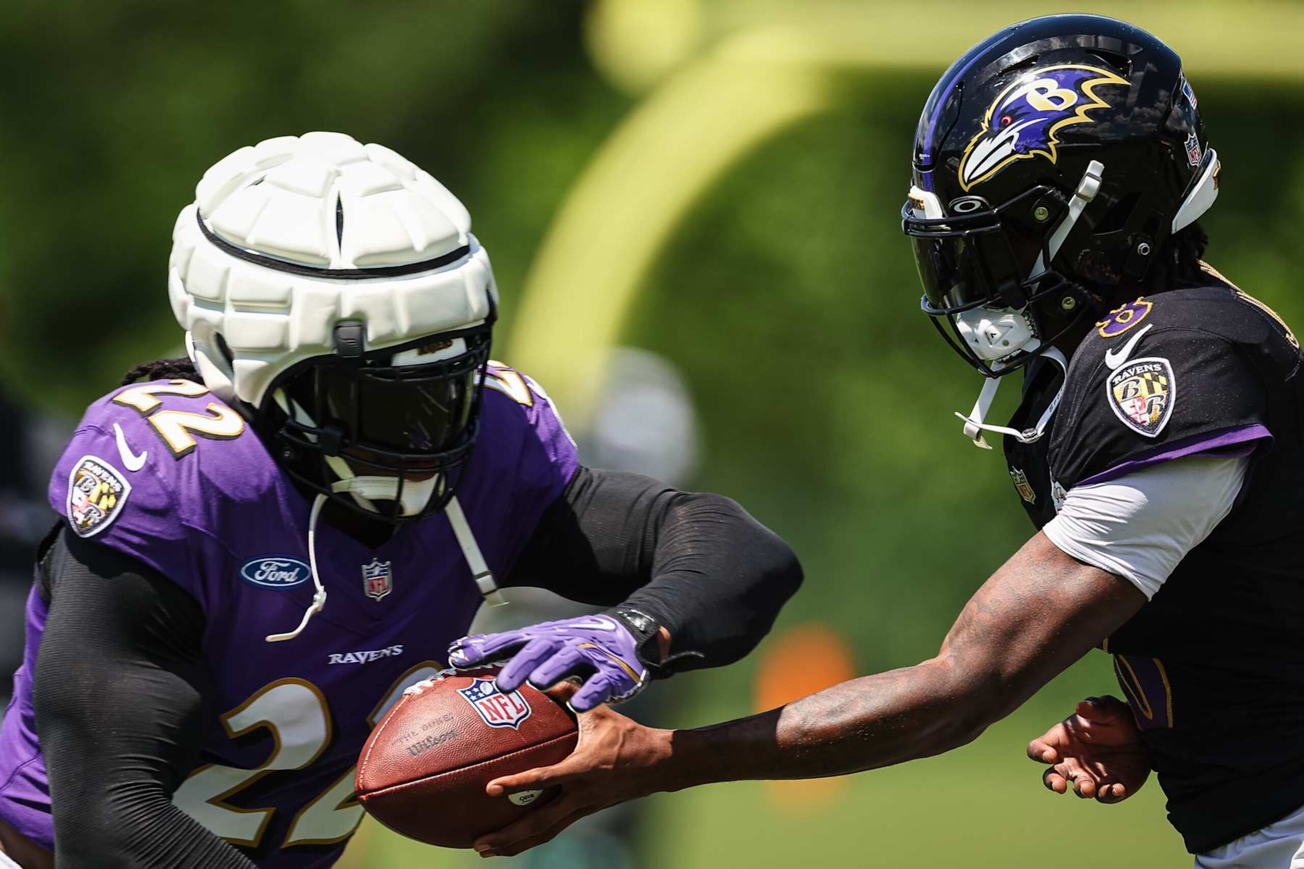 OWINGS MILLS, MD - AUGUST 12: Lamar Jackson #8 of the Baltimore Ravens hands the ball off to Derrick Henry #22 during training camp at Under Armour Performance Center Baltimore Ravens on August 12, 2024 in Owings Mills, Maryland. (Photo by Scott Taetsch/Getty Images)