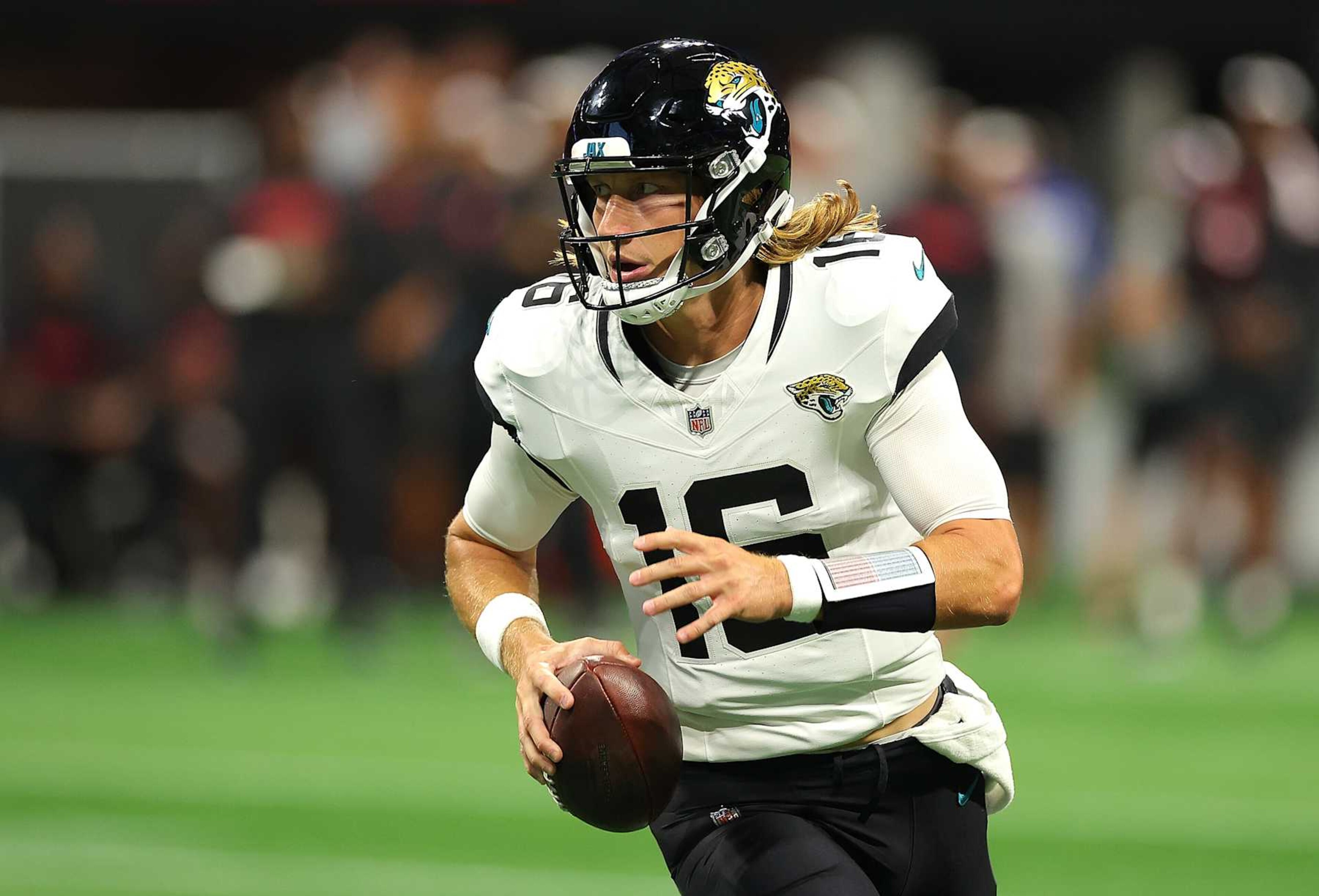 ATLANTA, GEORGIA - AUGUST 23: Trevor Lawrence #16 of the Jacksonville Jaguars looks to pass the ball as he rolls out of the pocket against the Atlanta Falcons during the first quarter at Mercedes-Benz Stadium on August 23, 2024 in Atlanta, Georgia. (Photo by Kevin C. Cox/Getty Images) ATLANTA, GEORGIA - AUGUST 23: Trevor Lawrence #16 of the Jacksonville Jaguars looks to pass the ball as he rolls out of the pocket against the Atlanta Falcons during the first quarter at Mercedes-Benz Stadium on August 23, 2024 in Atlanta, Georgia. (Photo by Kevin C. Cox/Getty Images)
