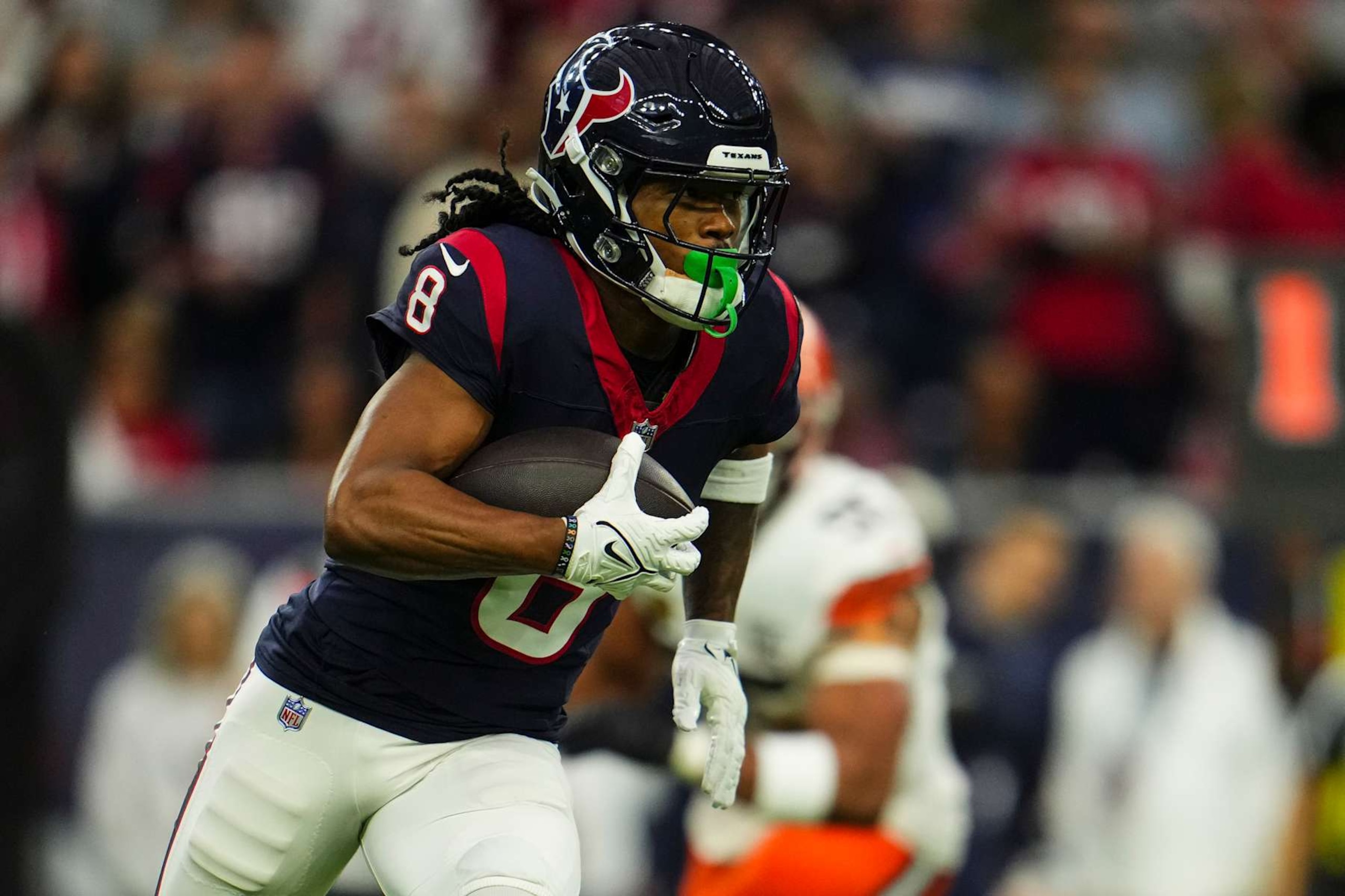 HOUSTON, TX - JANUARY 13: John Metchie III #8 of the Houston Texans runs the ball during an NFL wild-card playoff football game against the Cleveland Browns at NRG Stadium on January 13, 2024 in Houston, Texas. (Photo by Cooper Neill/Getty Images)