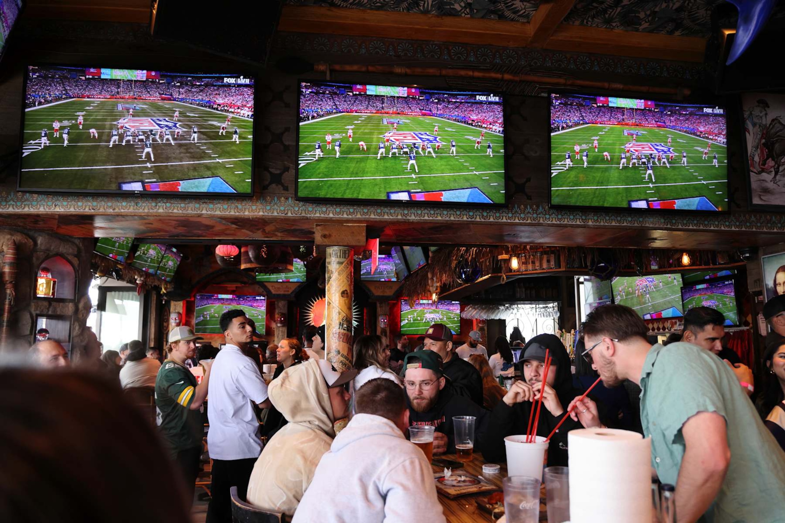 NEWPORT BEACH, CALIFORNIA - FEBRUARY 12: People watch Super Bowl LVII between the Philadelphia Eagles and the Kansas City Chiefs on televisions at a bar on February 12, 2023 in Newport Beach, California. (Photo by I RYU/VCG via Getty Images)