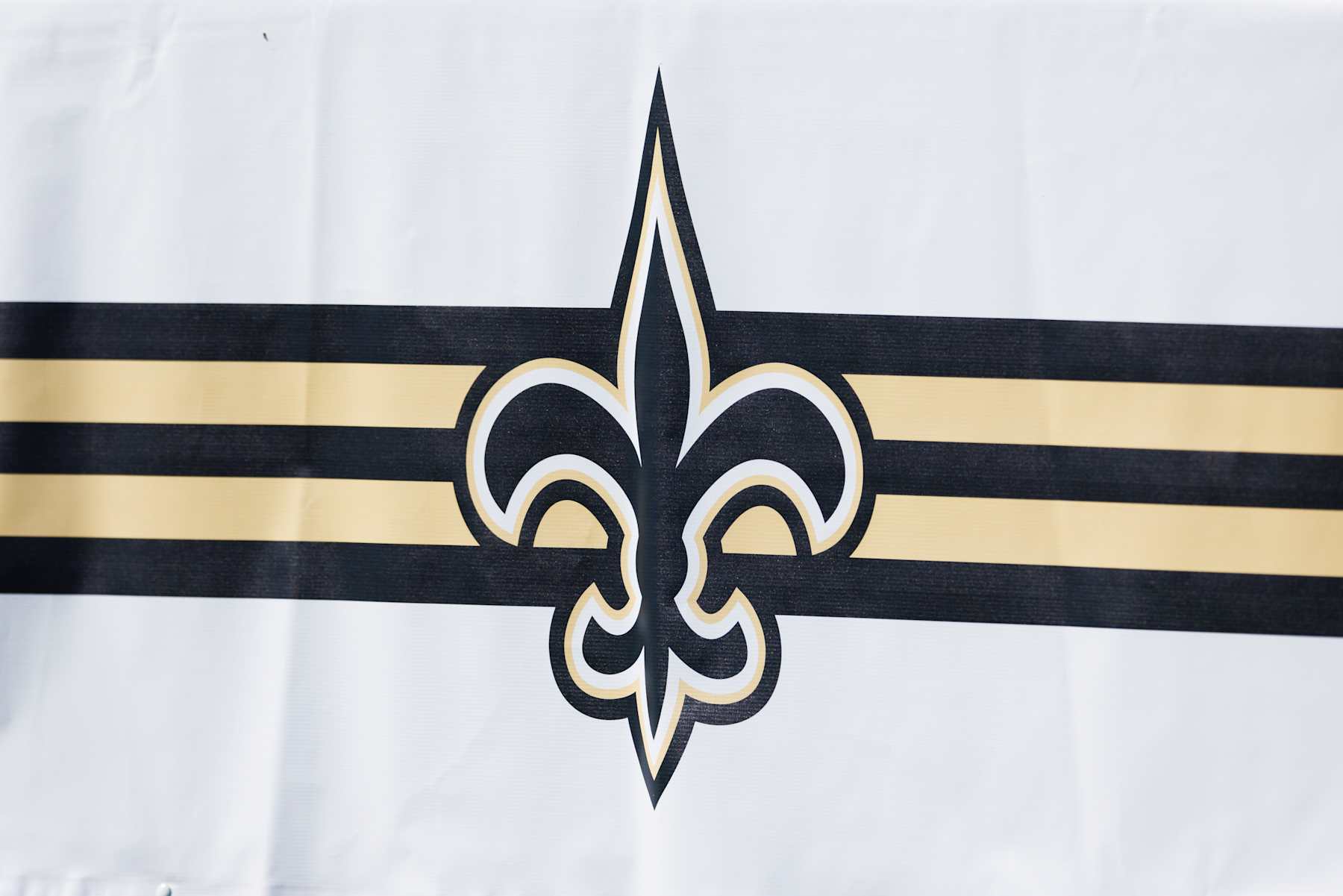 IRVINE, CALIFORNIA - JULY 29: A detail view of a New Orleans Saints logo on a sign during training camp at University of California Irvine on July 29, 2024 in Irvine, California.  (Photo by Ric Tapia/Getty Images)