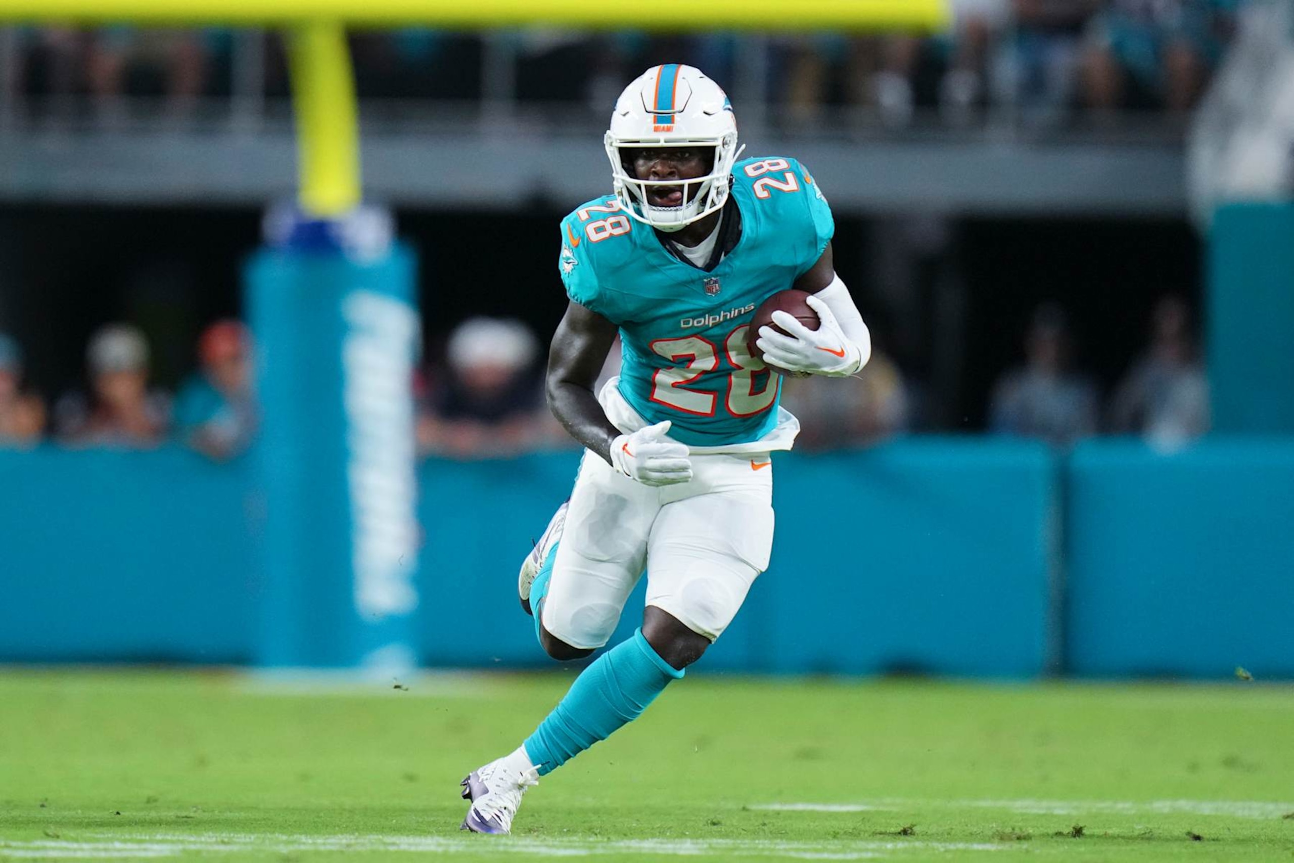 MIAMI GARDENS, FLORIDA - AUGUST 17: De'Von Achane #28 of the Miami Dolphins runs the ball against the Washington Commanders during the first half in a preseason game at Hard Rock Stadium on August 17, 2024 in Miami Gardens, Florida.  (Photo by Rich Storry/Getty Images)