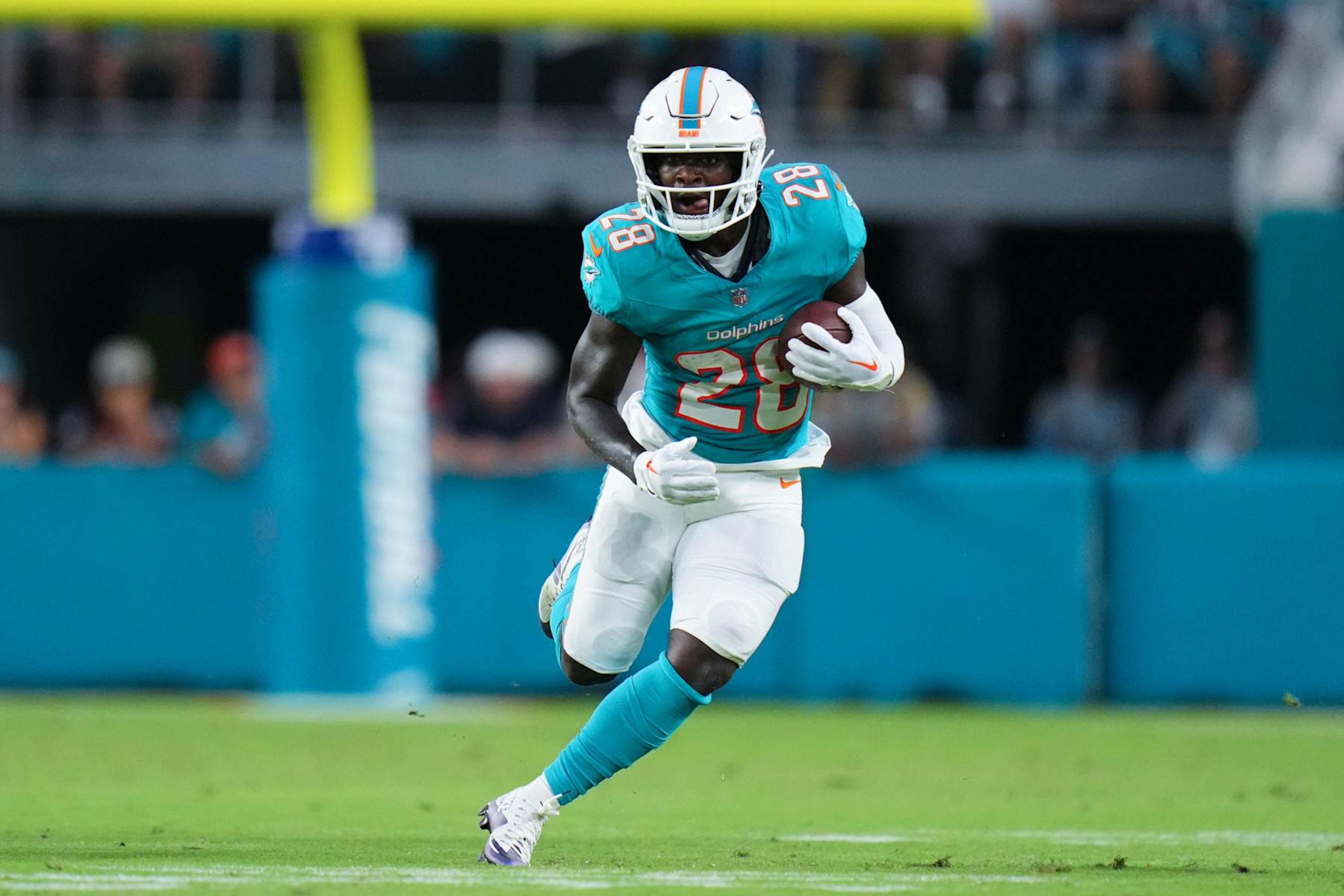 MIAMI GARDENS, FLORIDA - AUGUST 17: De'Von Achane #28 of the Miami Dolphins runs the ball against the Washington Commanders during the first half in a preseason game at Hard Rock Stadium on August 17, 2024 in Miami Gardens, Florida.  (Photo by Rich Storry/Getty Images)