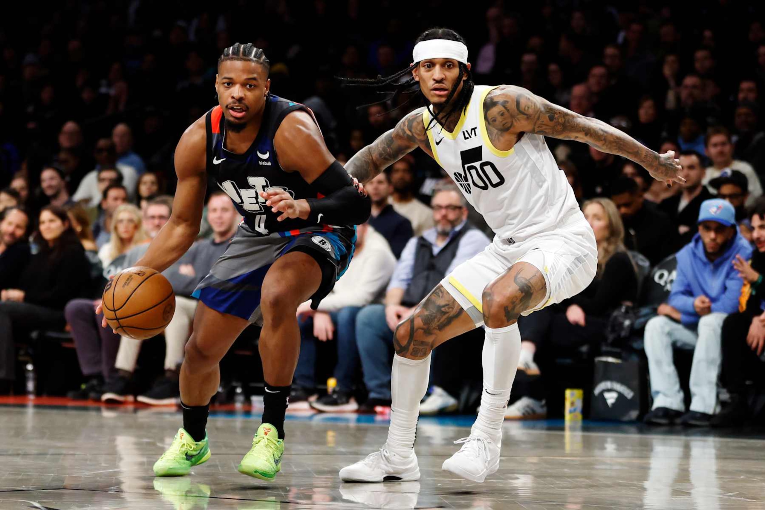 NEW YORK, NEW YORK - JANUARY 29: Dennis Smith Jr. #4 of the Brooklyn Nets dribbles against Jordan Clarkson #00 of the Utah Jazz during the second half at Barclays Center on January 29, 2024 in the Brooklyn borough of New York City. The Nets won 147-114. NOTE TO USER: User expressly acknowledges and agrees that, by downloading and/or using this Photograph, user is consenting to the terms and conditions of the Getty Images License Agreement. (Photo by Sarah Stier/Getty Images)