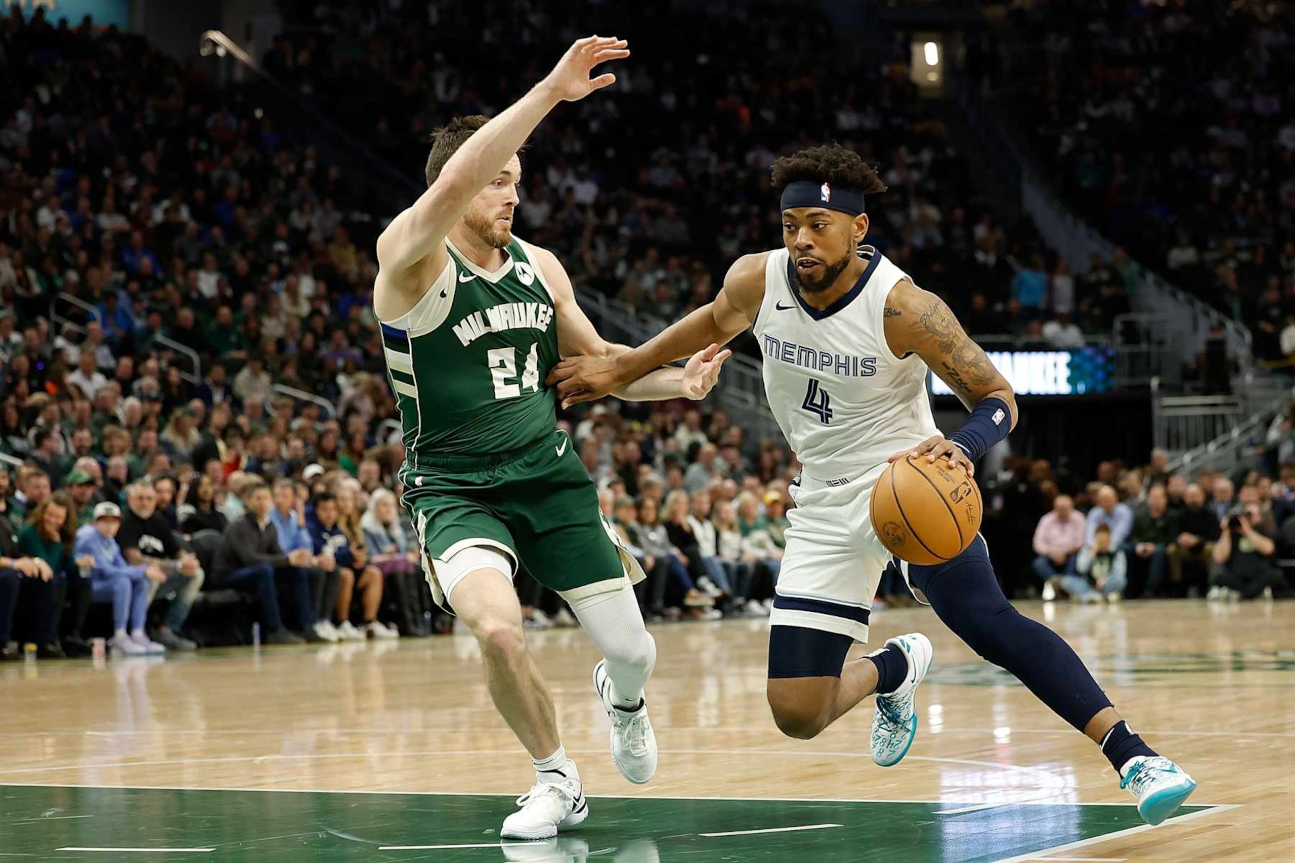 MILWAUKEE, WISCONSIN - APRIL 03: Jordan Goodwin #4 of the Memphis Grizzlies drives to the basket on Pat Connaughton #24 of the Milwaukee Bucks at Fiserv Forum on April 03, 2024 in Milwaukee, Wisconsin. NOTE TO USER: User expressly acknowledges and agrees that, by downloading and or using this photograph, User is consenting to the terms and conditions of the Getty Images License Agreement. (Photo by John Fisher/Getty Images)