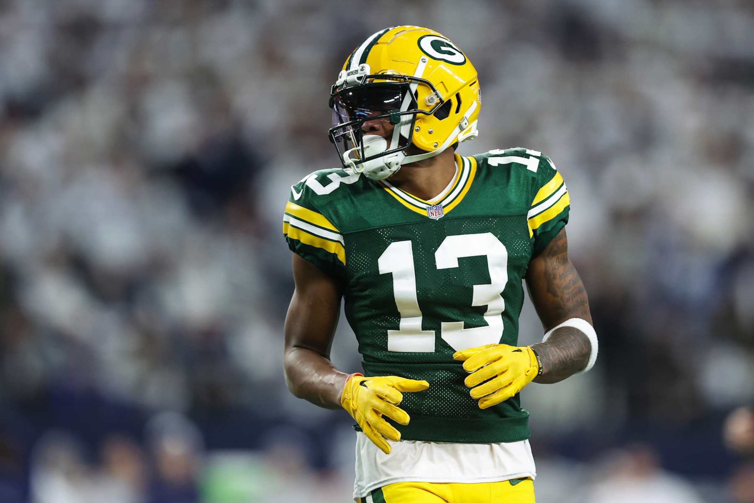 ARLINGTON, TX - JANUARY 14: Dontayvion Wicks #13 of the Green Bay Packers looks on from the field during an NFL wild-card playoff football game against the Dallas Cowboys at AT&T Stadium on January 14, 2024 in Arlington, Texas. (Photo by Perry Knotts/Getty Images)