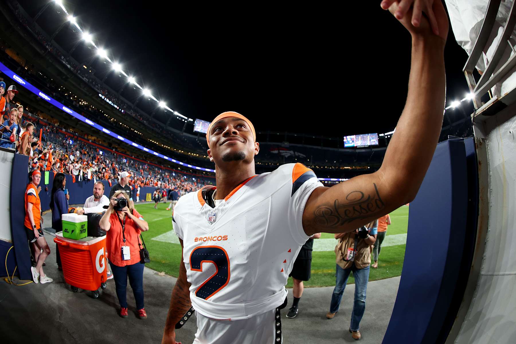 DENVER, COLORADO - AUGUST 18: Pat Surtain II #2 of the Denver Broncos high fives a fan against the Green Bay Packers during a preseason game at Empower Field At Mile High on August 18, 2024 in Denver, Colorado. (Photo by Jamie Schwaberow/Getty Images)