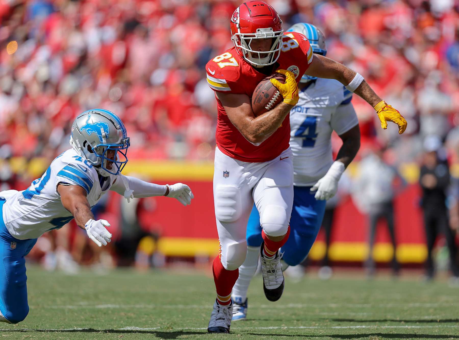 KANSAS CITY, MISSOURI - AUGUST 17: Travis Kelce #87 of the Kansas City Chiefs runs after a first quarter pass catch past Brandon Joseph #40 of the Detroit Lions during a preseason game at GEHA Field at Arrowhead Stadium on August 17, 2024 in Kansas City, Missouri. (Photo by David Eulitt/Getty Images)