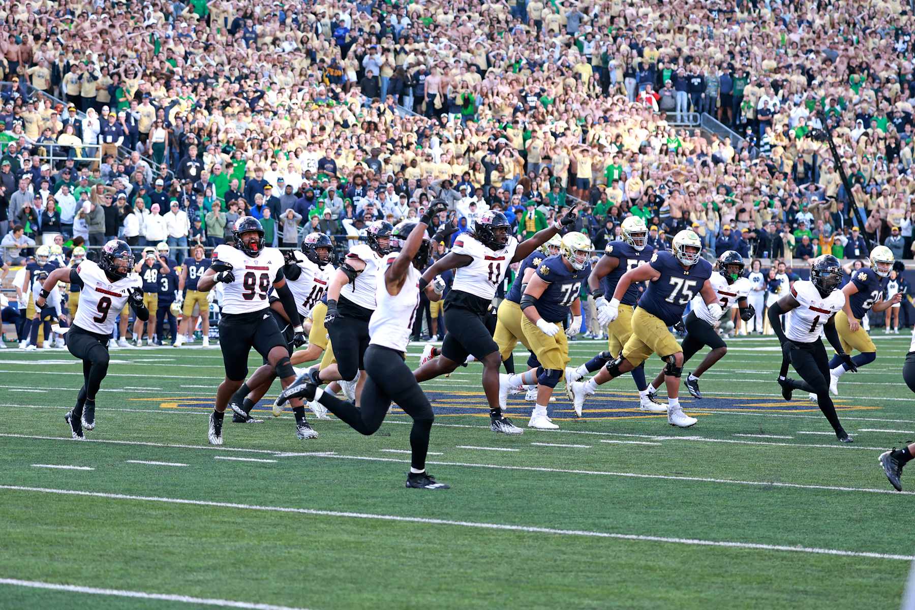 SOUTH BEND, IN - SEPTEMBER 07: Northern Illinois Huskies defensive end Pierce Oppong (99) and his teammates react to the upset victory against the Notre Dame Fighting Irish on September 7, 2024, at Notre Dame Stadium in South Bend, Indiana. (Photo by Brian Spurlock/Icon Sportswire via Getty Images)