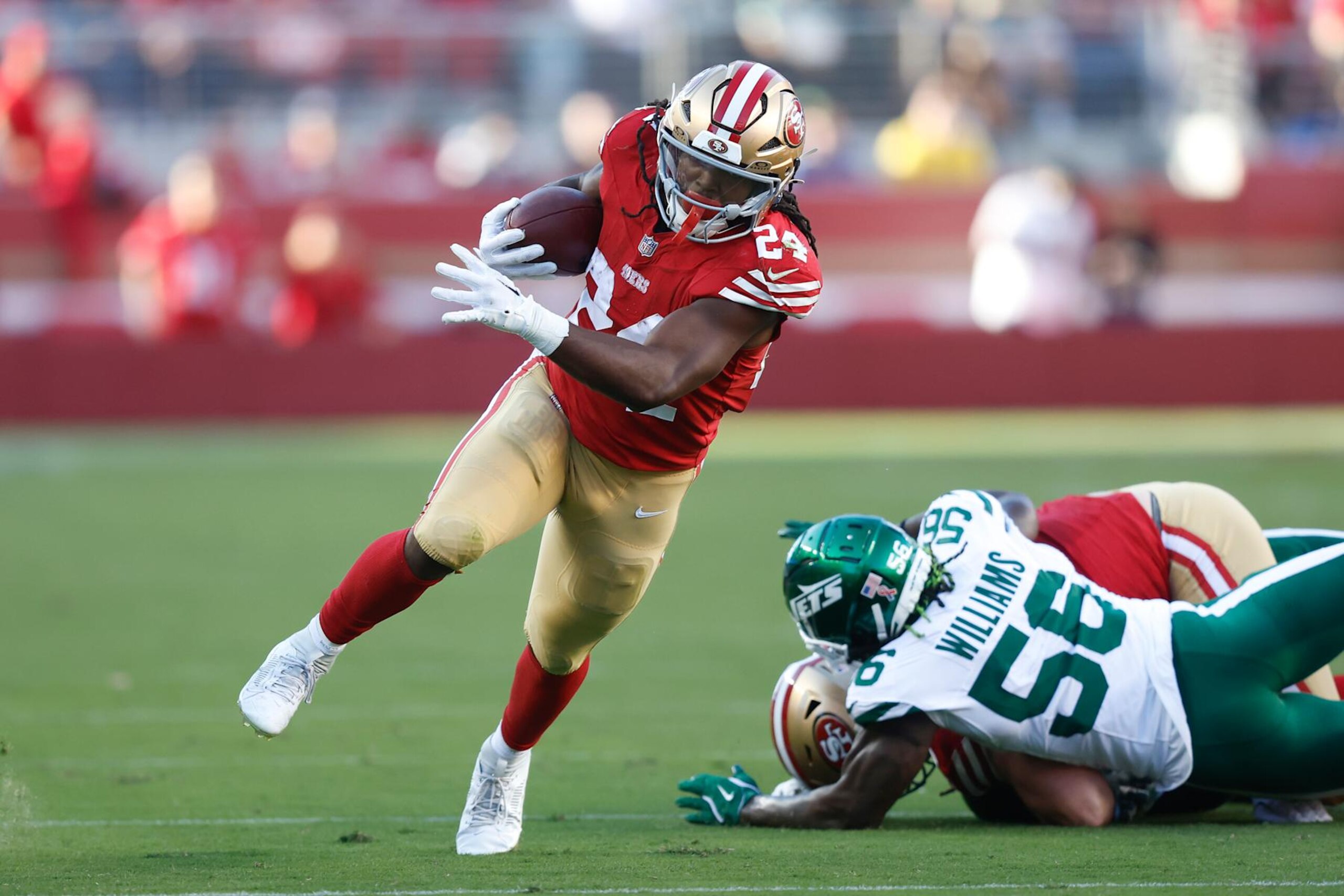 SANTA CLARA, CALIFORNIA - SEPTEMBER 09: Jordan Mason #24 of the San Francisco 49ers runs with the ball against Quincy Williams #56 of the New York Jets during the first half at Levi's Stadium on September 09, 2024 in Santa Clara, California. (Photo by Lachlan Cunningham/Getty Images)