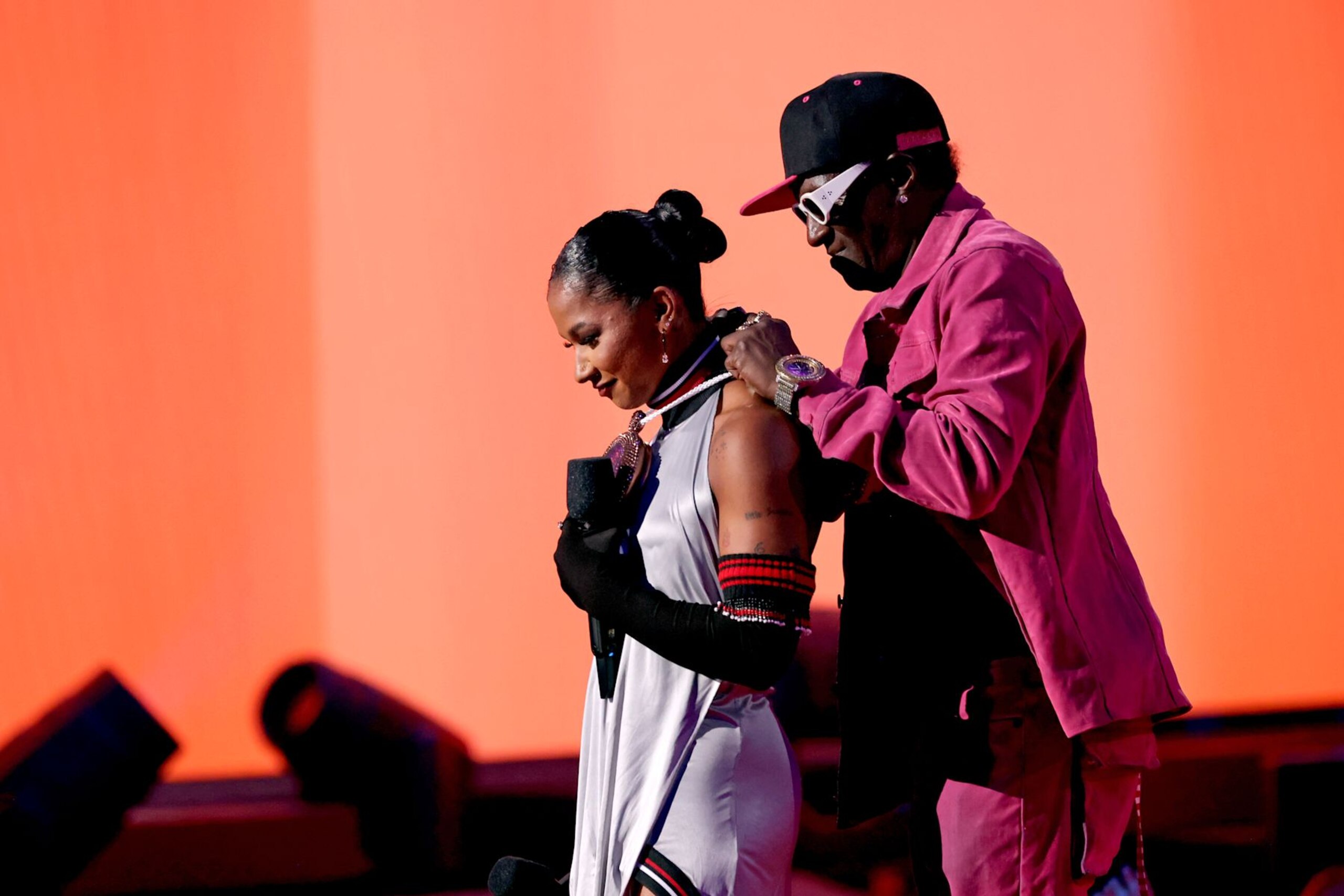 ELMONT, NEW YORK - SEPTEMBER 11: (L-R) Jordan Chiles and Flavor Flav speak on stage during the 2024 MTV Video Music Awards at UBS Arena on September 11, 2024 in Elmont, New York.  (Photo by Michael Loccisano/Getty Images for MTV)