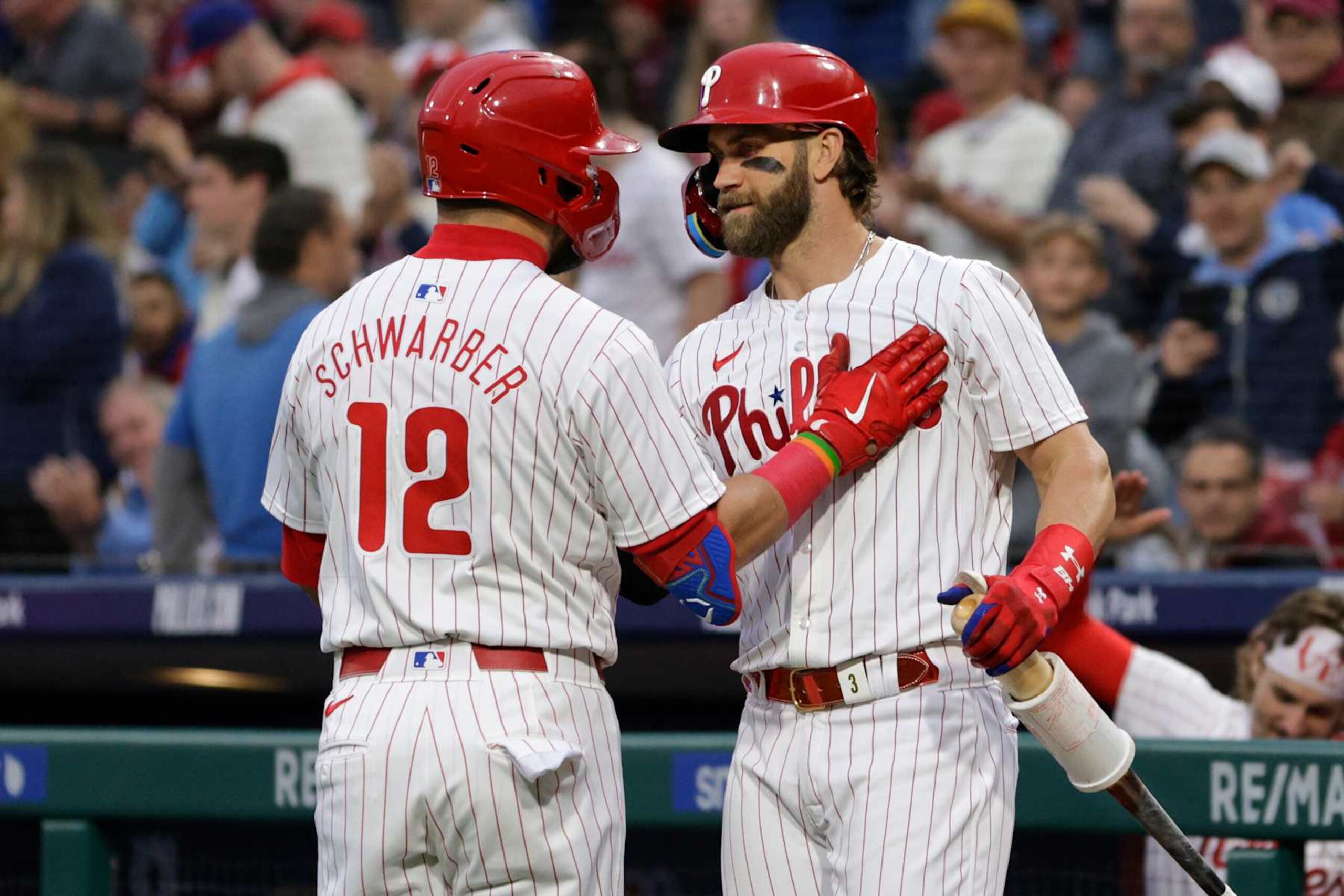 PHILADELPHIA, PENNSYLVANIA - APRIL 17: Kyle Schwarber #12 of the Philadelphia Phillies is congratulated by Bryce Harper #3 after he hit a home run against the Colorado Rockies during the first inning of a game at Citizens Bank Park on April 17, 2024 in Philadelphia, Pennsylvania. (Photo by Rich Schultz/Getty Images)