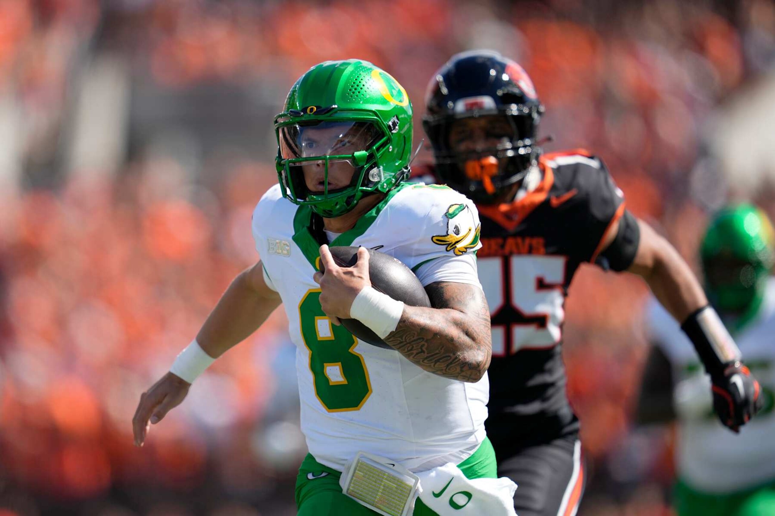 CORVALLIS, OREGON - SEPTEMBER 14: Dillon Gabriel #8 of the Oregon Ducks runs with the ball for a touchdown while pursued by Nikko Taylor #25 of the Oregon State Beavers during the first half at Reser Stadium on September 14, 2024 in Corvallis, Oregon.  (Photo by Soobum Im/Getty Images)
