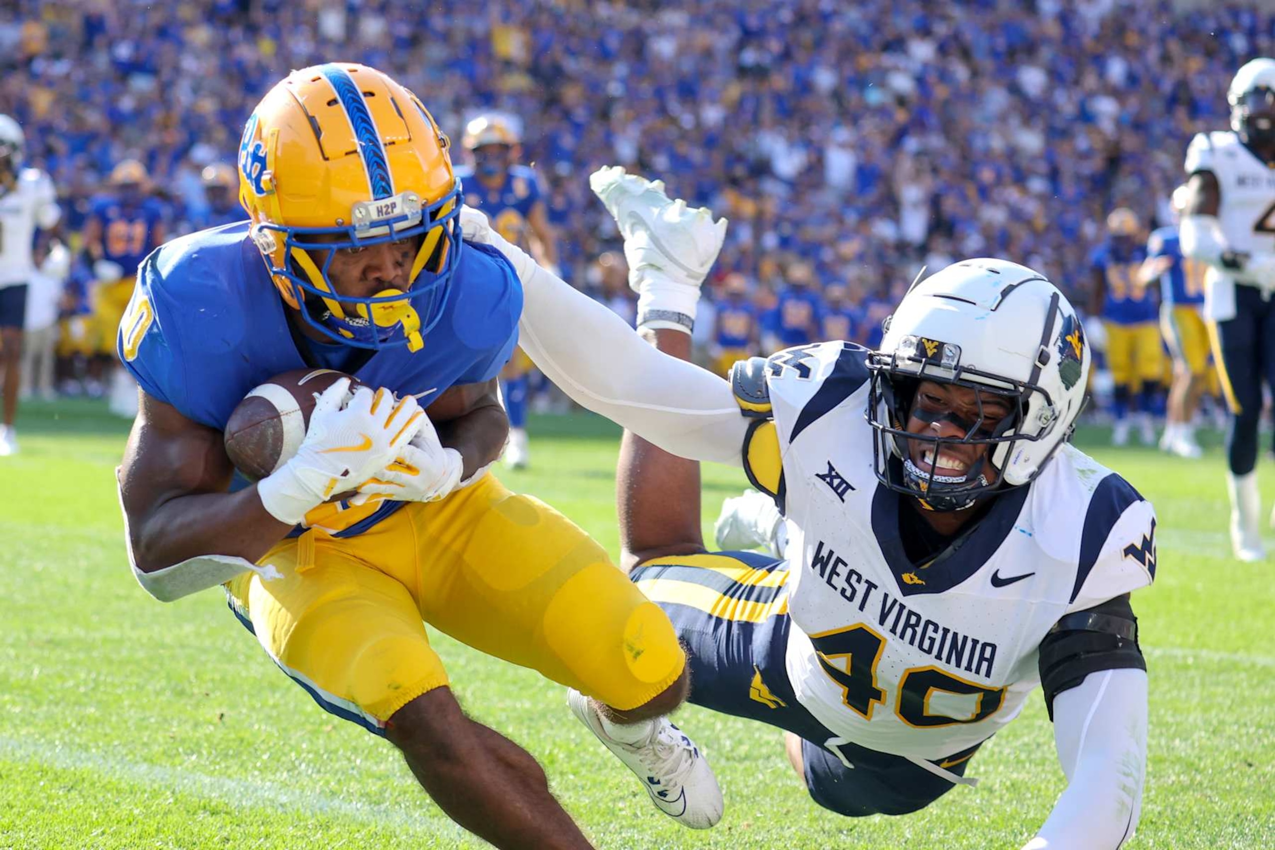 PITTSBURGH, PA - SEPTEMBER 14: Pittsburgh Panthers running back Desmond Reid (0) scores on a 19-yard touchdown pass as West Virginia Mountaineers linebacker Josiah Trotter (40) defends during the second quarter of the college football game between the West Virginia Mountaineers and Pitt Panthers on September 14, 2024, at Acrisure Stadium in Pittsburgh, PA. (Photo by Frank Jansky/Icon Sportswire via Getty Images)