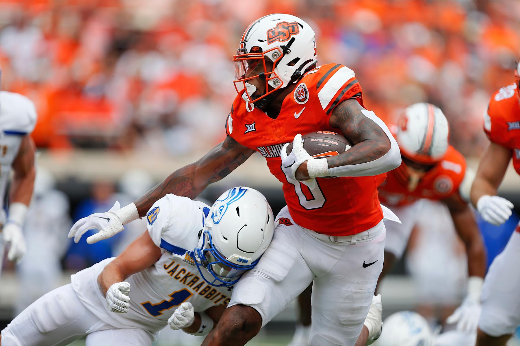 STILLWATER, OK - AUGUST 31: Running back Ollie Gordon II #0 of the Oklahoma State Cowboys powers his way into the end zone for a 12-yard touchdown past safety Tucker Large #1 of the South Dakota State Jackrabbits in the second quarter at Boone Pickens Stadium on August 31, 2024 in Stillwater, Oklahoma. Oklahoma State leads 17-6 after the first half. (Photo by Brian Bahr/Getty Images)