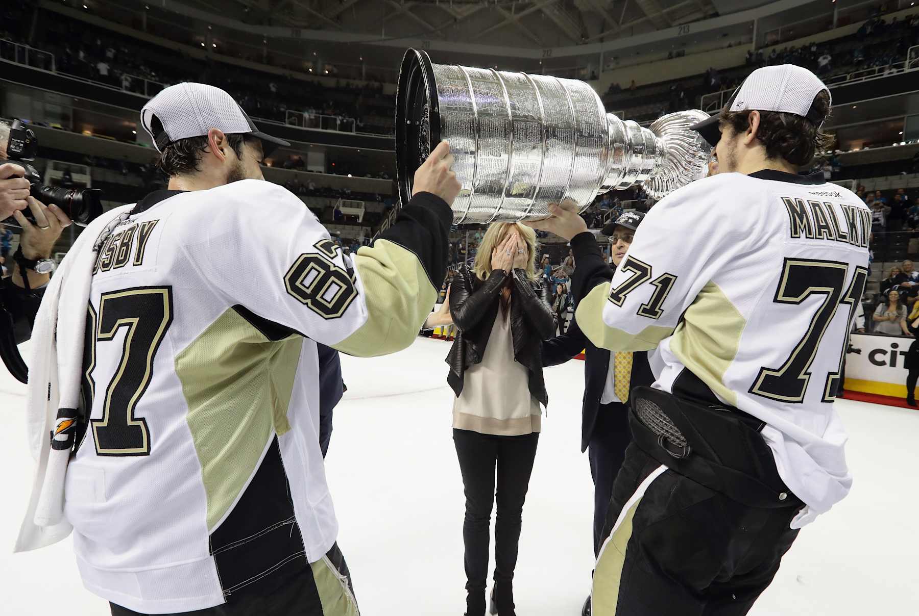 SAN JOSE, CA - JUNE 12: Sidney Crosby #87 and Evgeni Malkin #71 of the Pittsburgh Penguins carry the Stanley Cup to Nathalie Lemieux (wife of Mario) after defeating the San Jose Sharks in Game Six of the 2016 NHL Stanley Cup Final at SAP Center on June 12, 2016 in San Jose, California. (Photo by Bruce Bennett/Getty Images)