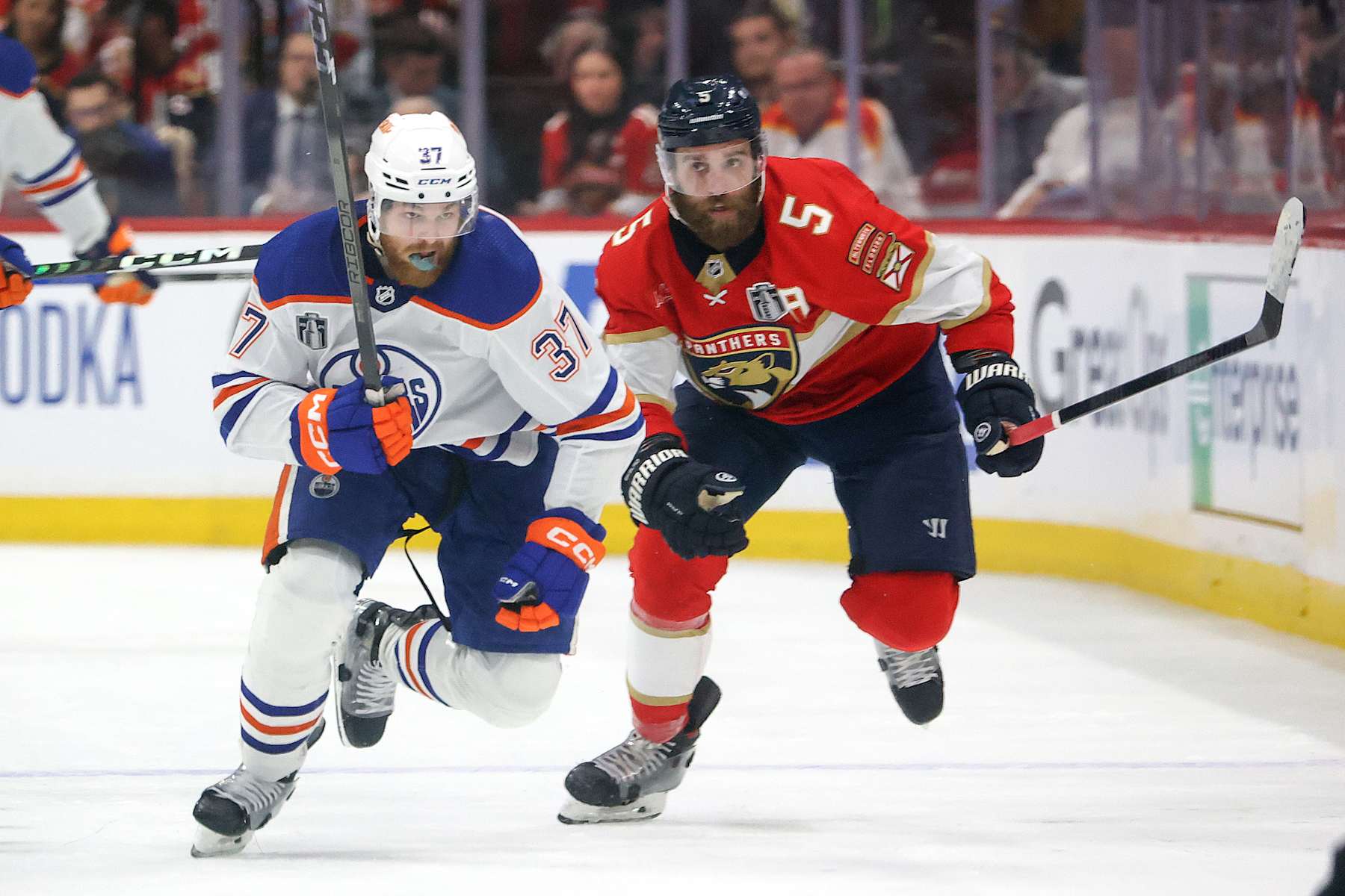 SUNRISE, FL - JUNE 18: Warren Foegele #37 of the Edmonton Oilers and Aaron Ekblad #5 of the Florida Panthers rush up ice in Game Five of the Final of the 2024 Stanley Cup Playoffs at the Amerant Bank Arena on June 18, 2024 in Sunrise, Florida. (Photo by Joel Auerbach/Getty Images)