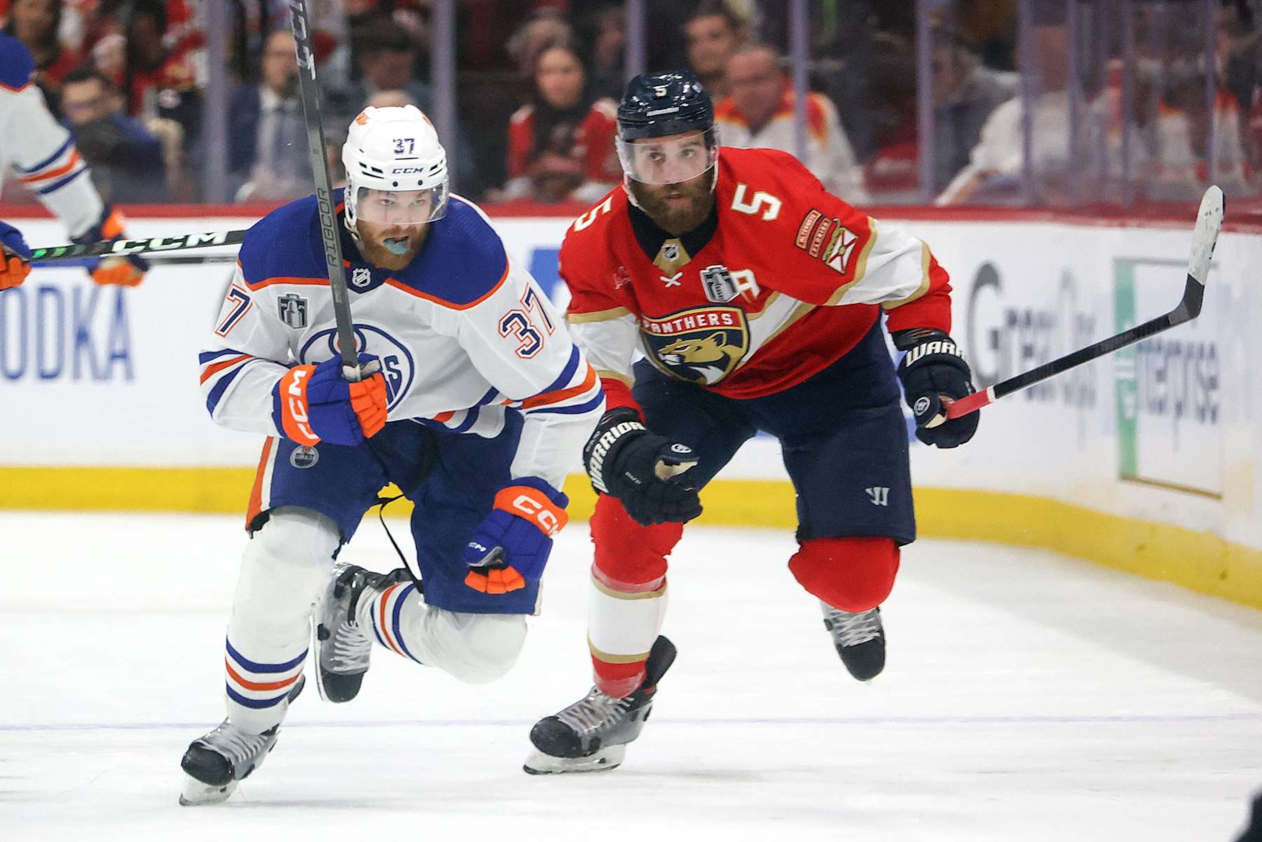 SUNRISE, FL - JUNE 18: Warren Foegele #37 of the Edmonton Oilers and Aaron Ekblad #5 of the Florida Panthers rush up ice in Game Five of the Final of the 2024 Stanley Cup Playoffs at the Amerant Bank Arena on June 18, 2024 in Sunrise, Florida. (Photo by Joel Auerbach/Getty Images)