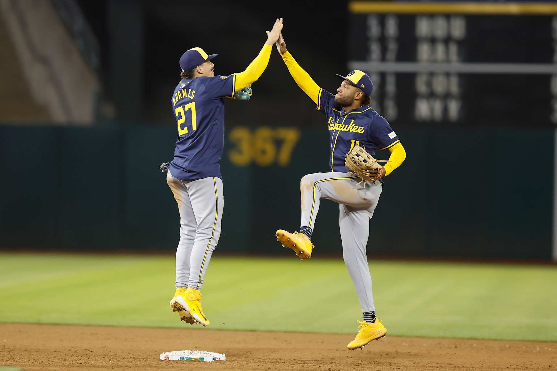 OAKLAND, CALIFORNIA - AUGUST 23: Willy Adames #27 and Jackson Chourio #11 of the Milwaukee Brewers celebrate after a win against the Oakland Athletics at Oakland Coliseum on August 23, 2024 in Oakland, California. (Photo by Lachlan Cunningham/Getty Images)