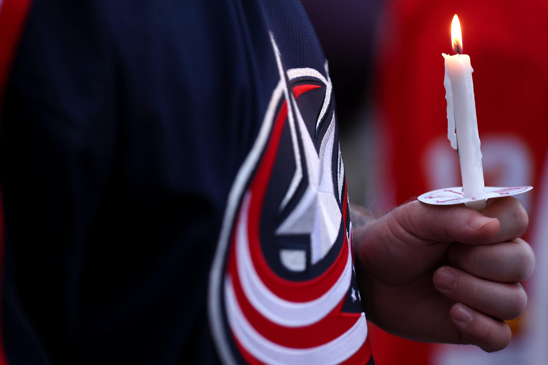 COLUMBUS, OHIO - SEPTEMBER 4:  A Columbus Blue Jackets fans holds a candle during at 13:21 minute money of silence during a candlelight vigil in remembrance of Johnny and Matthew Gaudreau at Nationwide Arena on September 4, 2024 in Columbus, Ohio. (Photo by Kirk Irwin/Getty Images)