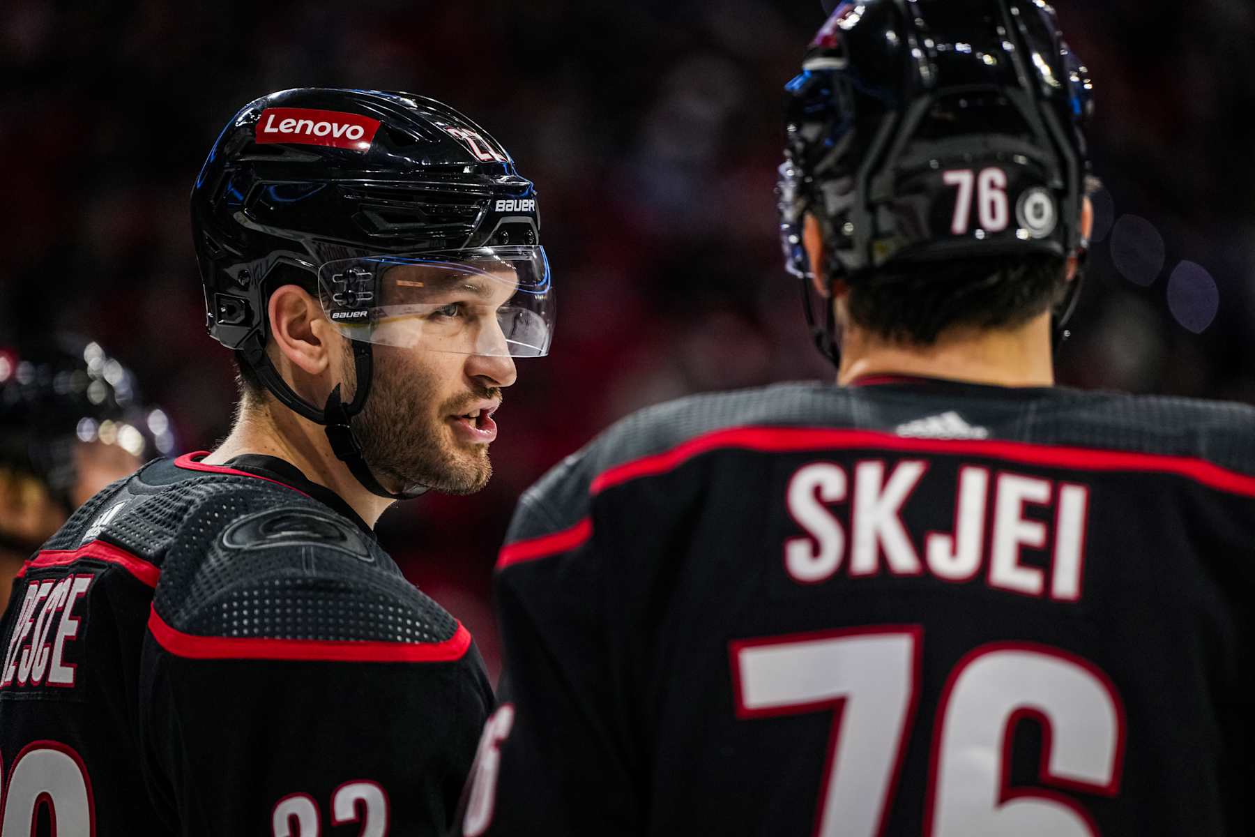 RALEIGH, NORTH CAROLINA - NOVEMBER 24: Brett Pesce #22 and Brady Skjei #76 of the Carolina Hurricanes talk during the second period against the Tampa Bay Lightning at PNC Arena on November 24, 2023 in Raleigh, North Carolina. (Photo by Josh Lavallee/NHLI via Getty Images)
