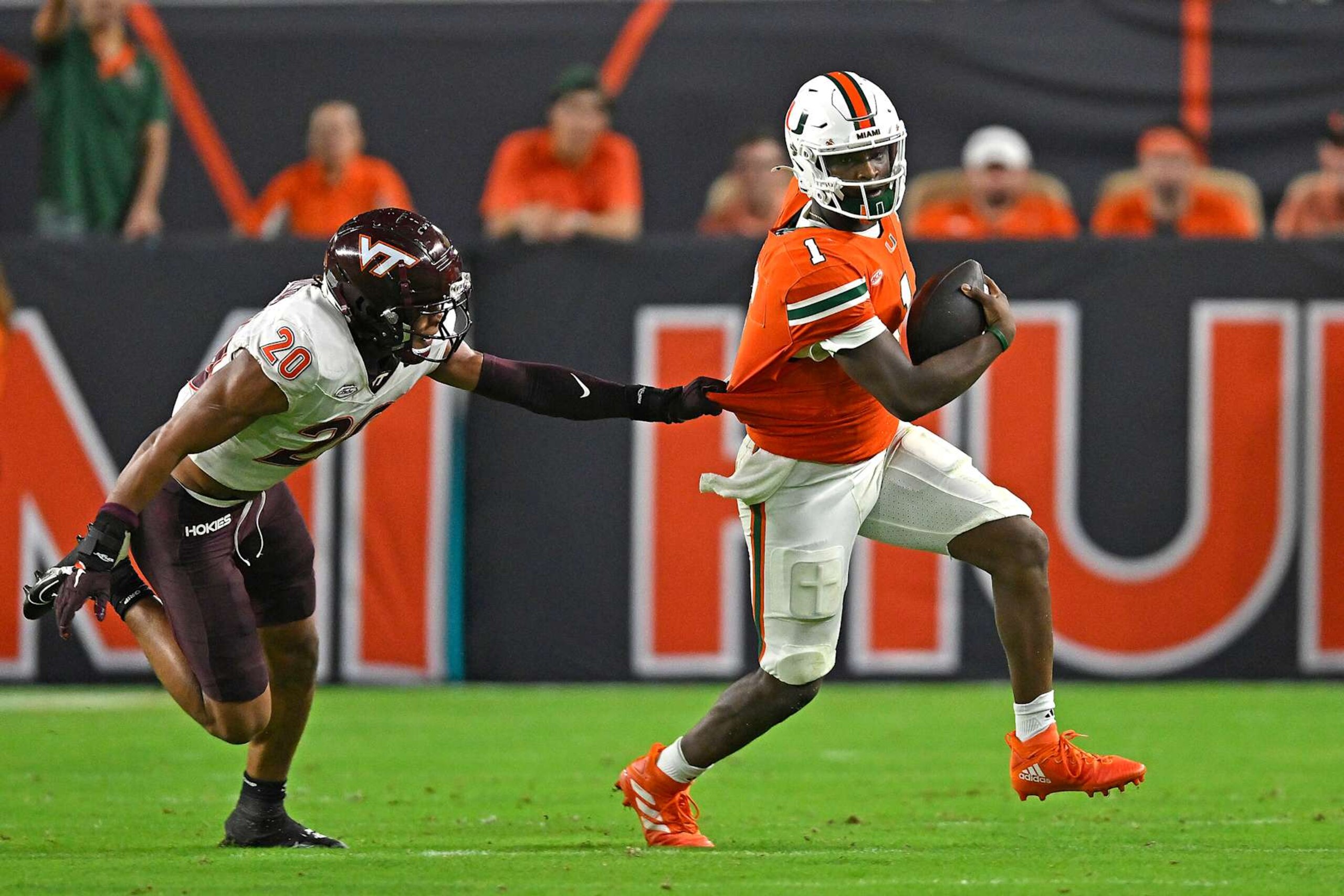 MIAMI GARDENS, FL - SEPTEMBER 27:  Miami quarterback Cam Ward (1) attempts to slip away from Virginia Tech linebacker Caleb Woodson (20) while carrying the ball in the first quarter as the Miami Hurricanes faced the Virginia Tech Hokies on September 27, 2024, at Hard Rock Stadium in Miami Gardens, Florida. (Photo by Samuel Lewis/Icon Sportswire via Getty Images)