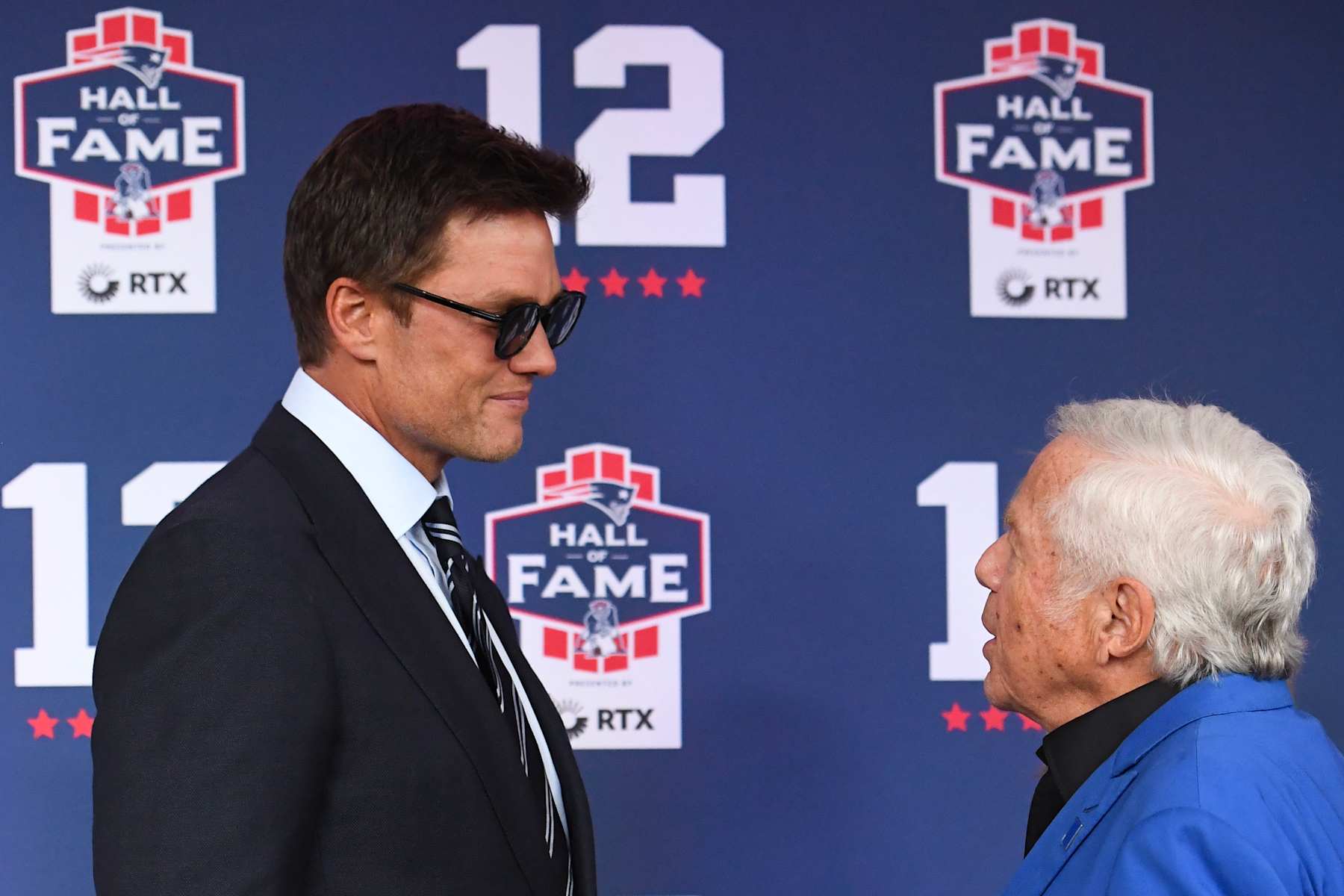FOXBOROUGH, MASSACHUSETTS - JUNE 12: Tom Brady talks with New England Patriots CEO Robert Kraft during the 2024 Hall of Fame Induction Ceremony for Tom Brady at Gillette Stadium on June 12, 2024 in Foxborough, Massachusetts. (Photo by China Wong/Getty Images)