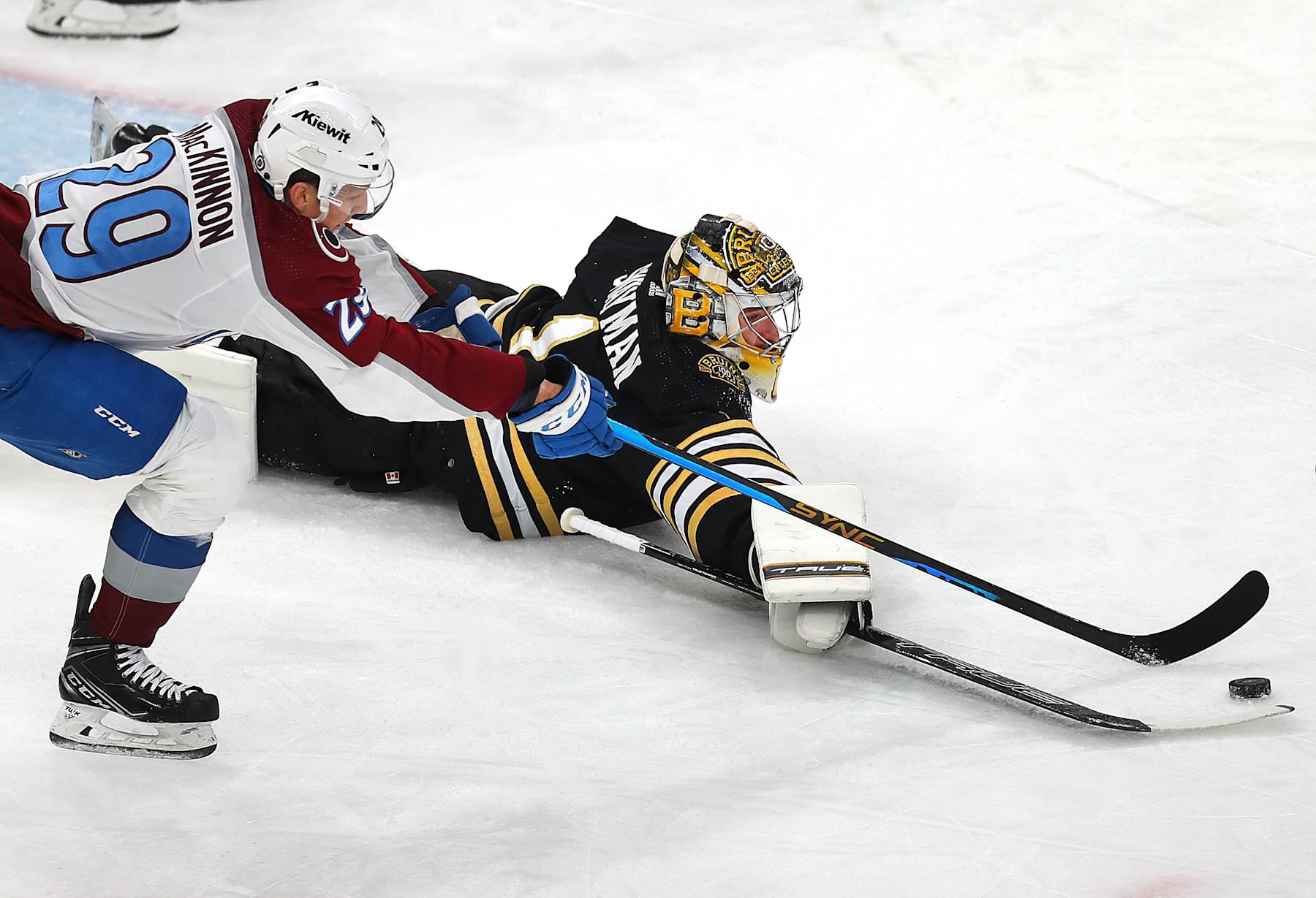 Boston, MA - January 18: Boston Bruins goalie Jeremy Swayman reaches out with his stick to clear the puck. The Bruins beat the Colorado Avalanche, 5-2. (Photo by John Tlumacki/The Boston Globe via Getty Images)