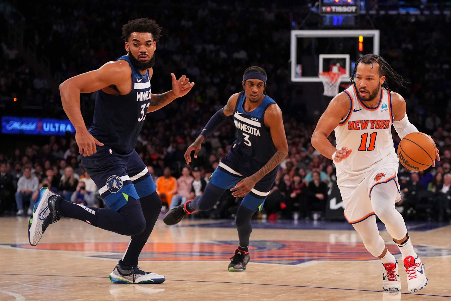 NEW YORK, NEW YORK - JANUARY 1: Jalen Brunson #11 of the New York Knicks dribbles the ball against Karl-Anthony Towns #32 and Jaden McDaniels #3 of the Minnesota Timberwolves at Madison Square Garden on January 1, 2024 in New York City. The Knicks defeated the Timberwolves 112-106. NOTE TO USER: User expressly acknowledges and agrees that, by downloading and or using this photograph, User is consenting to the terms and conditions of the Getty Images License Agreement. (Photo by Mitchell Leff/Getty Images)