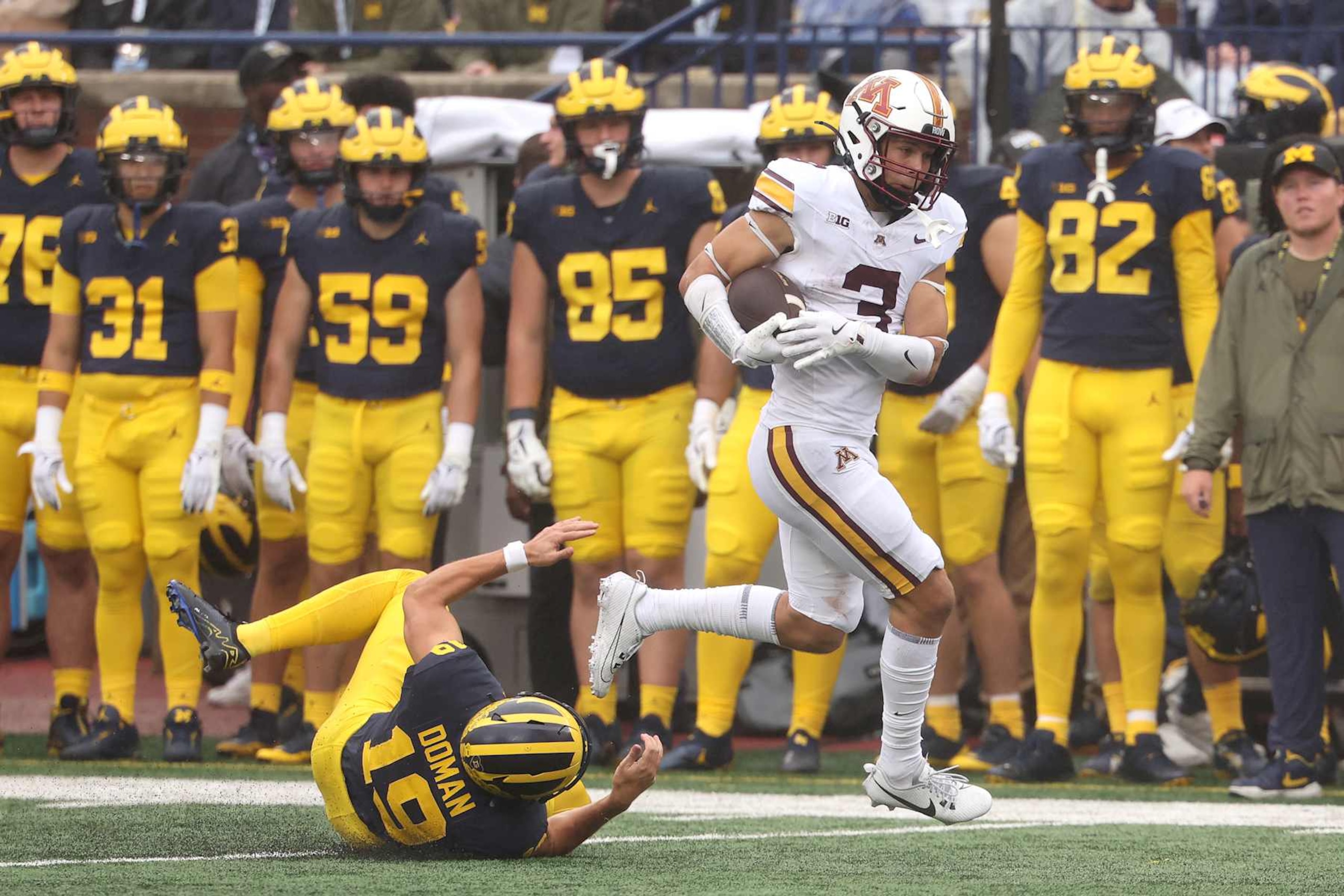 ANN ARBOR, MICHIGAN - SEPTEMBER 28: Koi Perich #3 of the Minnesota Golden Gophers returns a fourth quarter punt past Tommy Doman #19 of the Michigan Wolverines at Michigan Stadium on September 28, 2024 in Ann Arbor, Michigan.  (Photo by Gregory Shamus/Getty Images)
