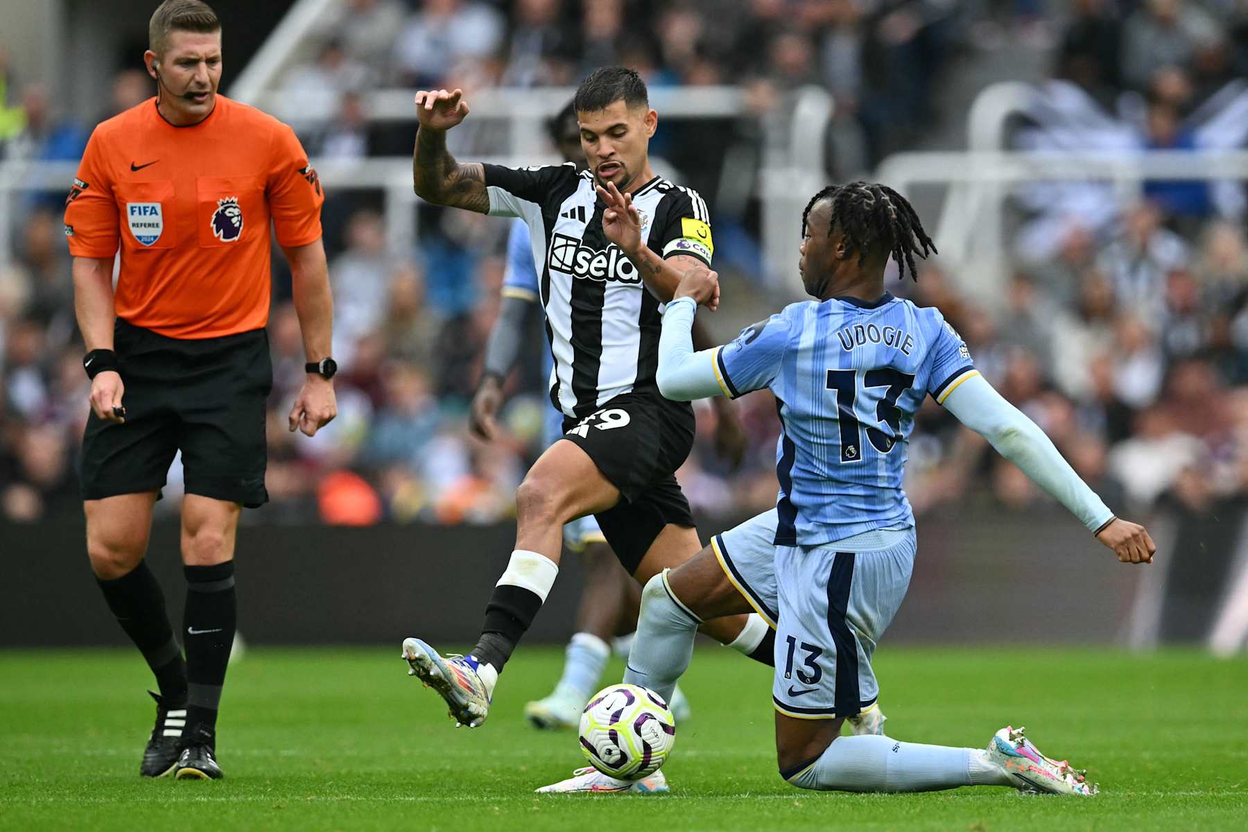 Tottenham Hotspur's Italian defender #13 Destiny Udogie (R) vies with Newcastle United's Brazilian midfielder #39 Bruno Guimaraes (C) during the English Premier League football match between Newcastle United and Tottenham Hotspur at St James' Park in Newcastle-upon-Tyne, north east England on September 1, 2024. (Photo by ANDY BUCHANAN / AFP) / RESTRICTED TO EDITORIAL USE. No use with unauthorized audio, video, data, fixture lists, club/league logos or 'live' services. Online in-match use limited to 120 images. An additional 40 images may be used in extra time. No video emulation. Social media in-match use limited to 120 images. An additional 40 images may be used in extra time. No use in betting publications, games or single club/league/player publications. / (Photo by ANDY BUCHANAN/AFP via Getty Images)