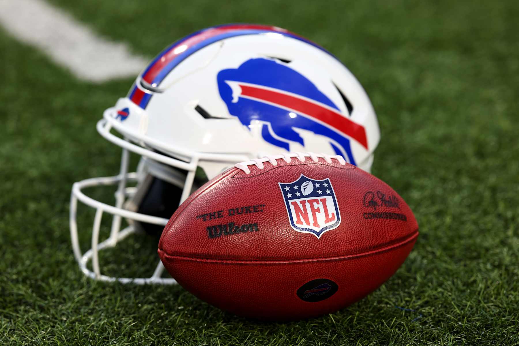 ORCHARD PARK, NY - SEPTEMBER 23: A detail shot of an official Wilson NFL football on the field next to a Buffalo Bills helmet prior to an NFL football game against the Jacksonville Jaguars at Highmark Stadium on September 23, 2024 in Orchard Park, New York. (Photo by Kevin Sabitus/Getty Images)