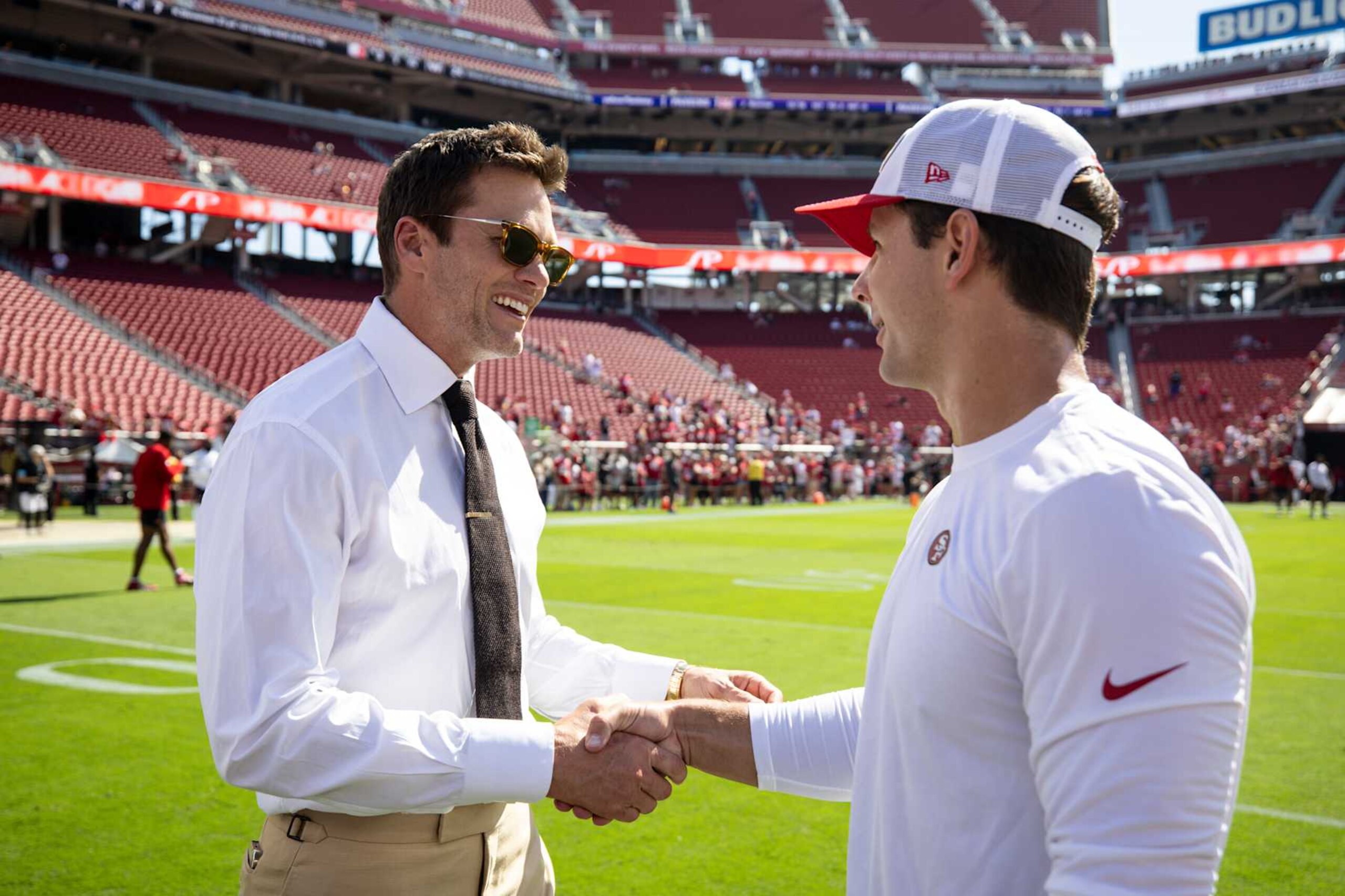 SANTA CLARA, CALIFORNIA - OCTOBER 6: Brock Purdy #13 of the San Francisco shakes hands with Fox Sports commentator and former NFL quarterback Tom Brady prior to an NFL Football game against the Arizona Cardinals at Levi's Stadium on October 06, 2024 in Santa Clara, California. (Photo by Michael Owens/Getty Images) SANTA CLARA, CALIFORNIA - OCTOBER 6: Brock Purdy #13 of the San Francisco shakes hands with Fox Sports commentator and former NFL quarterback Tom Brady prior to an NFL Football game against the Arizona Cardinals at Levi's Stadium on October 06, 2024 in Santa Clara, California. (Photo by Michael Owens/Getty Images)