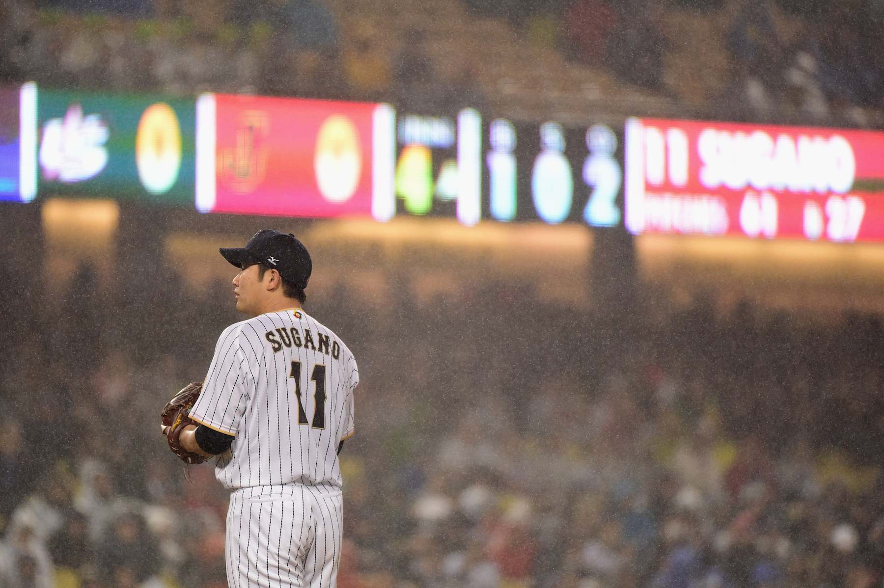 LOS ANGELES, CA - MARCH 21: Tomoyuki Sugano #11 of team Japan looks on in the rain during the fourth inning against team United States during Game 2 of the Championship Round of the 2017 World Baseball Classic at Dodger Stadium on March 21, 2017 in Los Angeles, California. (Photo by Harry How/Getty Images)
