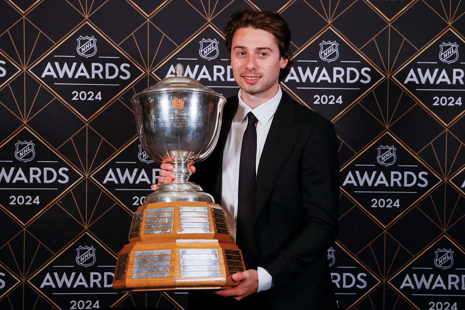 Quinn Hughes with the James Norris Memorial Trophy. 