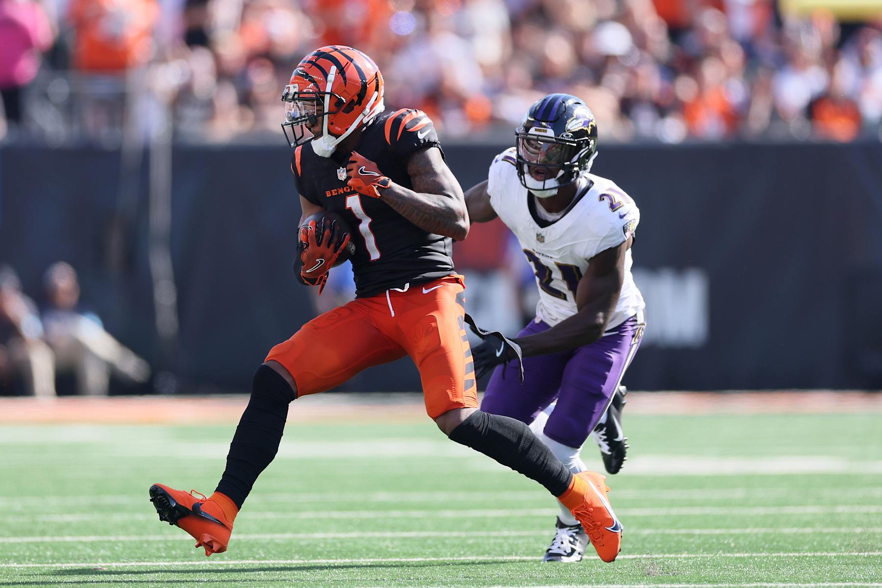 CINCINNATI, OHIO - OCTOBER 06: Ja'Marr Chase #1 of the Cincinnati Bengals runs after a catch as Brandon Stephens #21 of the Baltimore Ravens pursues a tackle during the fourth quarter at Paycor Stadium on October 06, 2024 in Cincinnati, Ohio. (Photo by Andy Lyons/Getty Images)