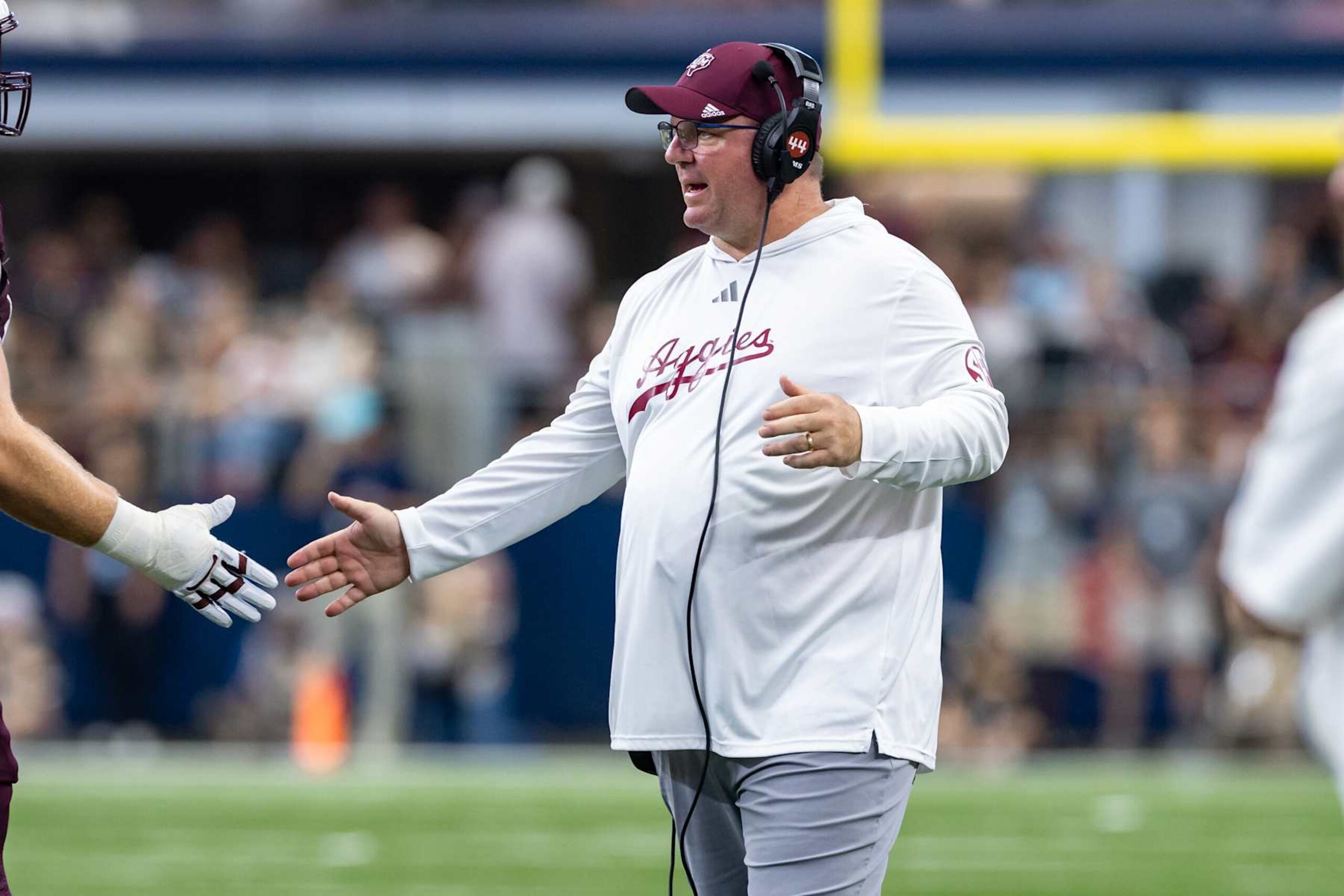 ARLINGTON, TX - SEPTEMBER 28: Texas A&M Aggies head coach Mike Elko high fives players as they come off the field during the college football game between the Arkansas Razorbacks and Texas A&M Aggies on September 28, 2024, at AT&T Stadium in Arlington, TX.  (Photo by Matthew Visinsky/Icon Sportswire via Getty Images)