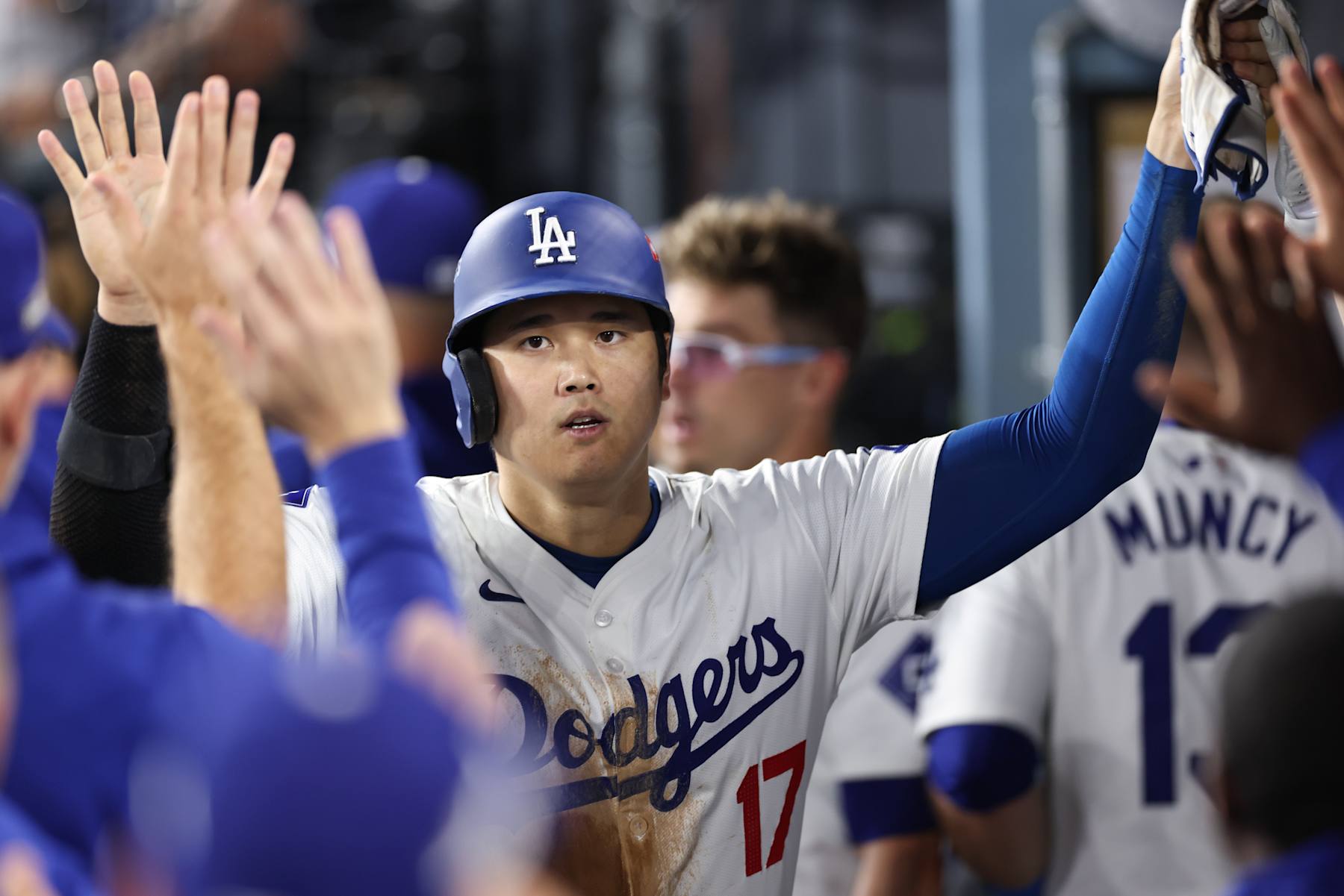 LOS ANGELES, CA - OCTOBER 13: Shohei Ohtani #17 of the Los Angeles Dodgers celebrates with teammates in the dugout after scoring on an RBI single hit by Freddie Freeman in the fourth inning during Game 1 of the NLCS between the New York Mets and the Los Angeles Dodgers at Dodger Stadium on Sunday, October 13, 2024 in Los Angeles, California. (Photo by Michael Owens/MLB Photos via Getty Images)