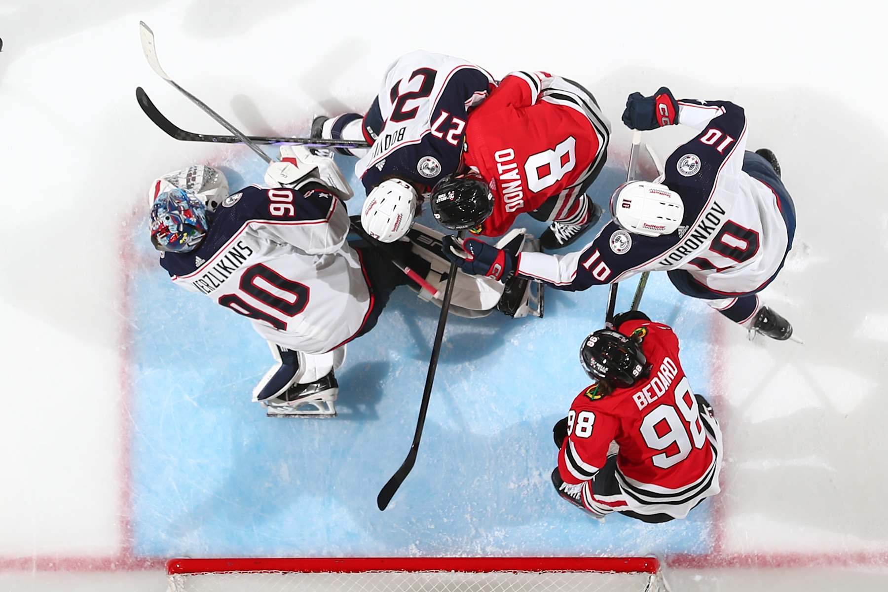 CHICAGO, ILLINOIS - MARCH 02: Adam Boqvist #27 of the Columbus Blue Jackets and Ryan Donato #8 of the Chicago Blackhawks work to get the puck next to goalie Elvis Merzlikins #90 of the Columbus Blue Jackets in the \ at the United Center on March 02, 2024 in Chicago, Illinois. (Photo by Chase Agnello-Dean/NHLI via Getty Images)