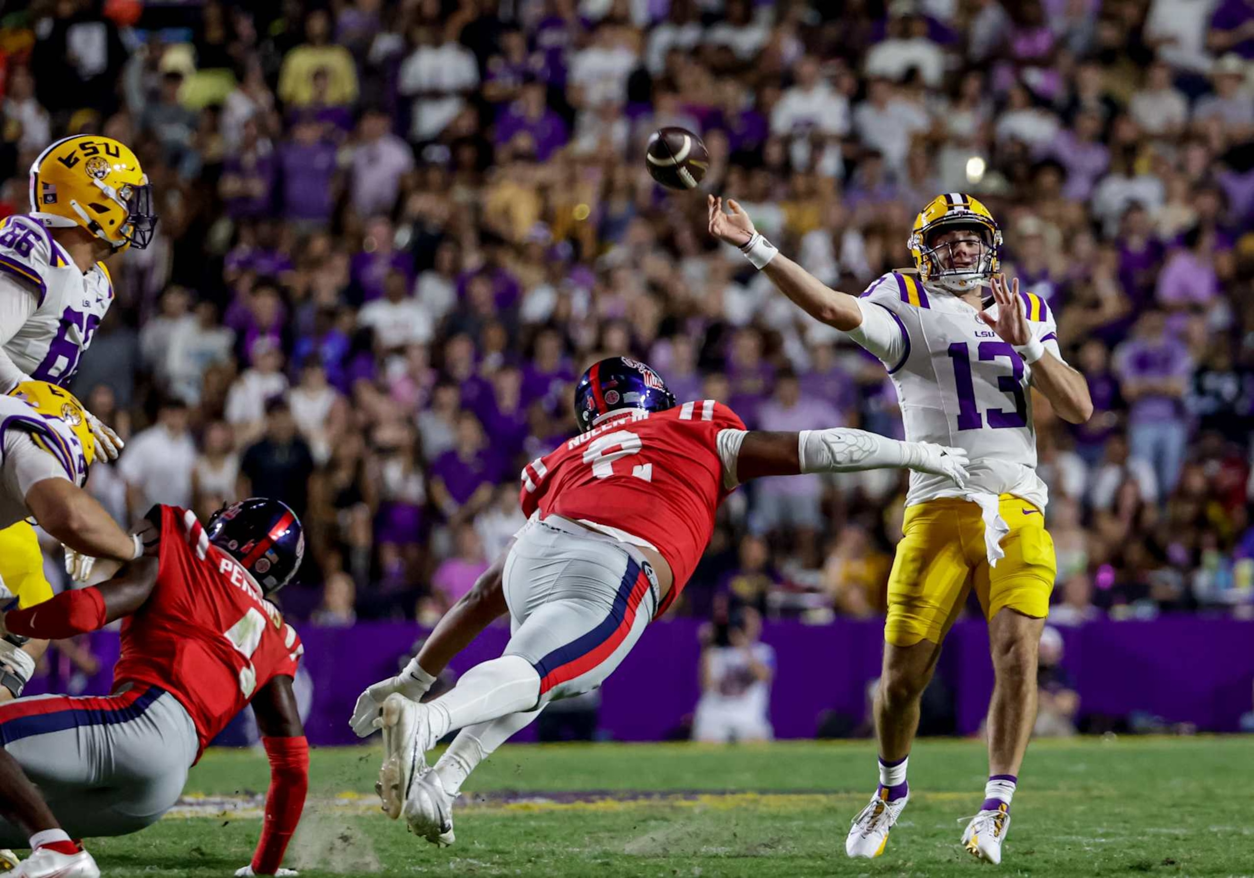 BATON ROUGE, LOUISIANA - OCTOBER 12: Garrett Nussmeier #13 of the LSU Tigers is pressured by Walter Nolen #2 of the Ole Miss Rebels during the first half of a game at Tiger Stadium on October 12, 2024 in Baton Rouge, Louisiana. (Photo by Derick E. Hingle/Getty Images)