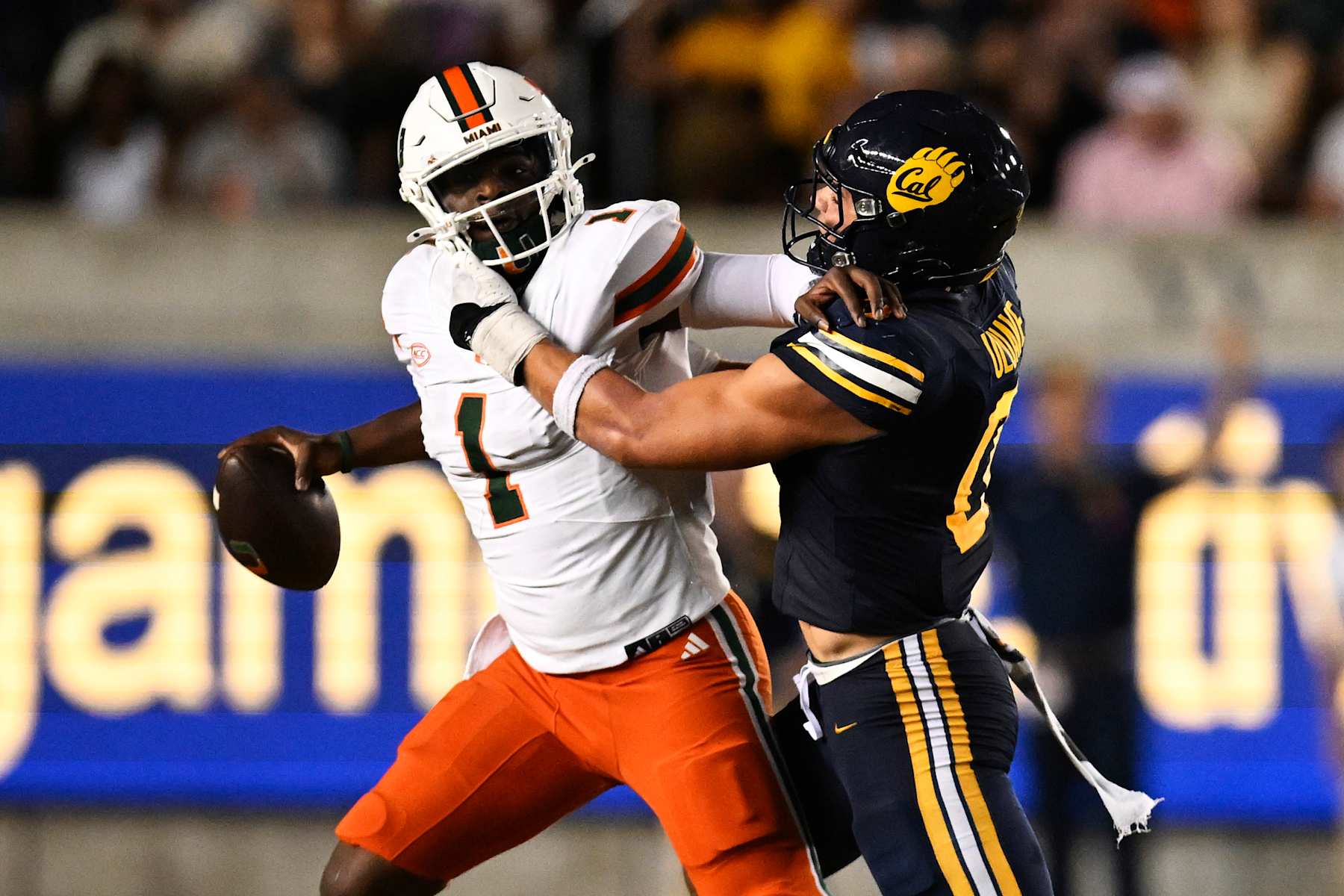 BERKELEY, CALIFORNIA - OCTOBER 05: Cam Ward #1 of the Miami Hurricanes gets rid of the ball to avoid a sack by Cade Uluave #0 of the California Golden Bears in the third quarter at California Memorial Stadium on October 05, 2024 in Berkeley, California. (Photo by Eakin Howard/Getty Images)
