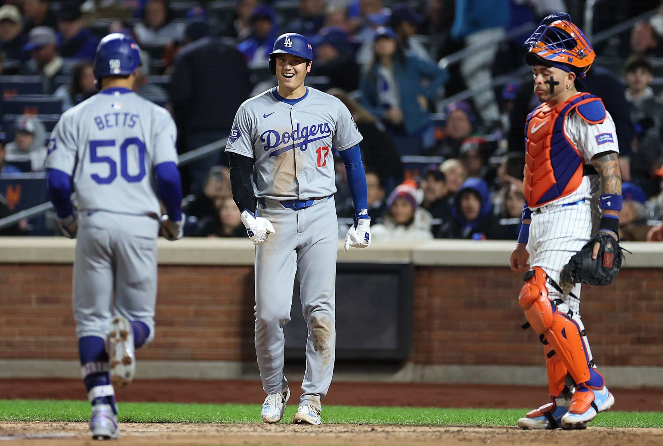 NEW YORK, NEW YORK - OCTOBER 17: Mookie Betts #50 of the Los Angeles Dodgers celebrates a two run home run with Shohei Ohtani #17 of the Los Angeles Dodgers as Francisco Alvarez #4 of the New York Mets reacts during the sixth inning against the New York Mets during Game Four of the National League Championship Series at Citi Field on October 17, 2024 in New York City. (Photo by Sarah Stier/Getty Images)