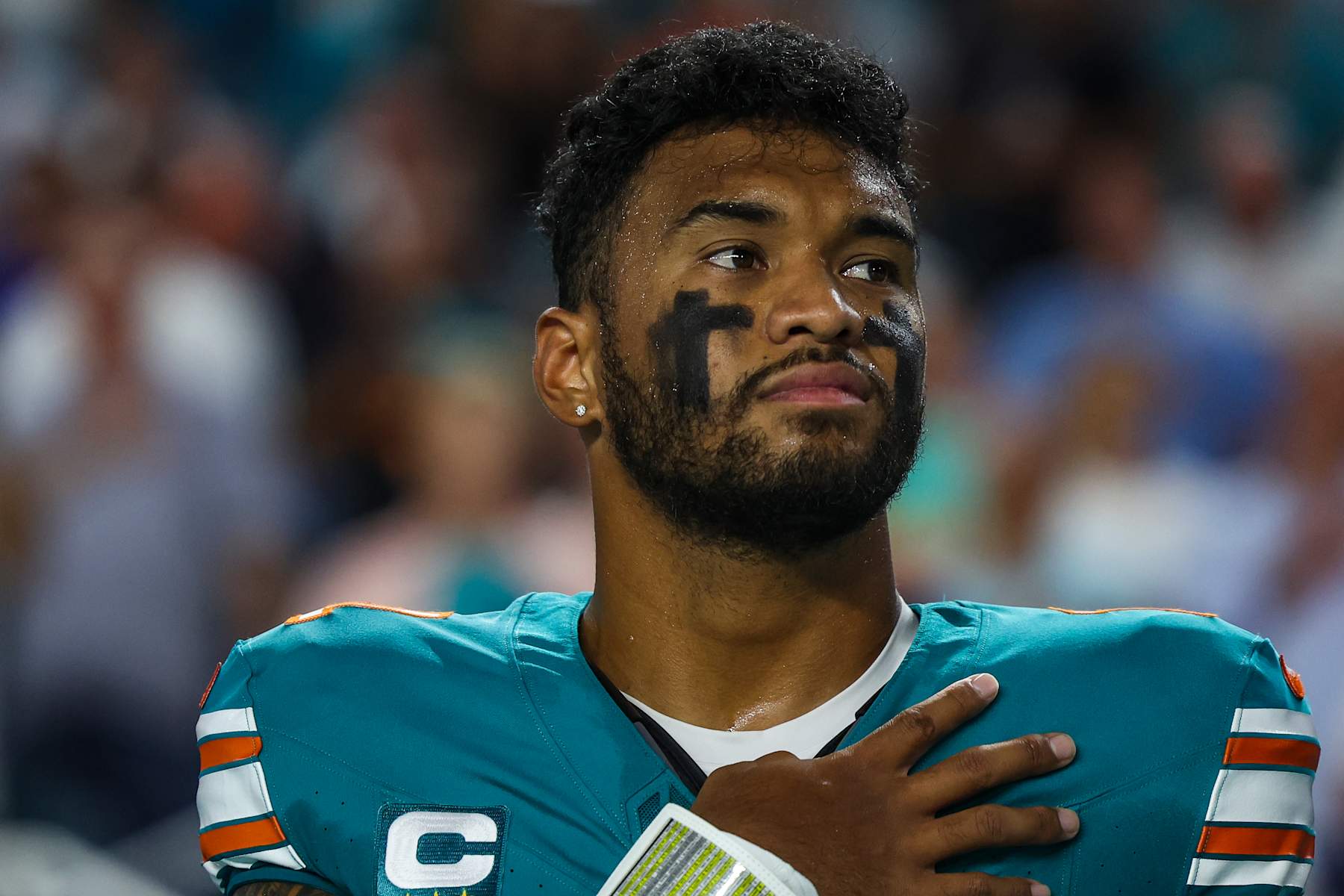MIAMI GARDENS, FL - SEPTEMBER 12: Tua Tagovailoa #1 of the Miami Dolphins looks on from the sideline during the national anthem prior to an NFL football game against the Buffalo Bills at Hard Rock Stadium on September 12, 2024 in Miami Gardens, FL. (Photo by Perry Knotts/Getty Images)