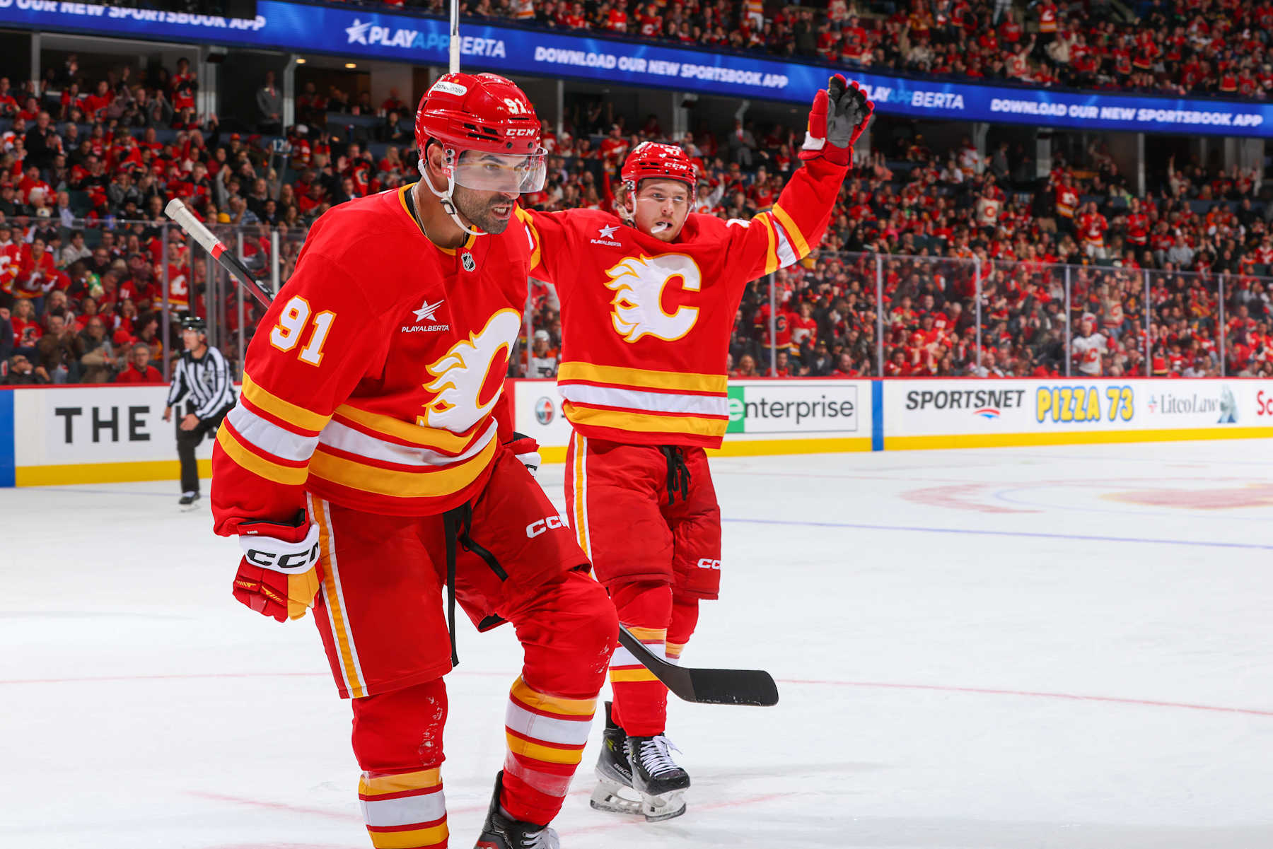 Calgary Flames forwards Nazem Kadri (91) and Connor Zary celebrate a goal.