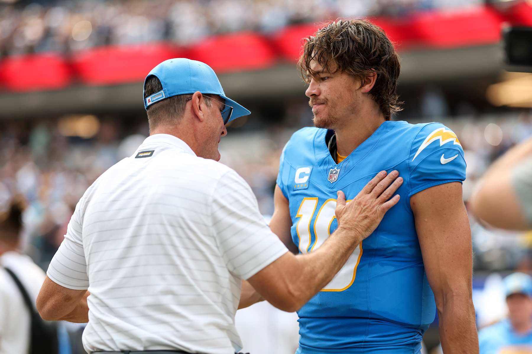 INGLEWOOD, CALIFORNIA - SEPTEMBER 08: Head coach Jim Harbaugh of the Los Angeles Chargers and Justin Herbert #10 of the Los Angeles Chargers share a moment prior to an NFL football game between the Los Angeles Chargers and the Las Vegas Raiders at SoFi Stadium on September 08, 2024 in Inglewood, California. (Photo by Michael Owens/Getty Images)