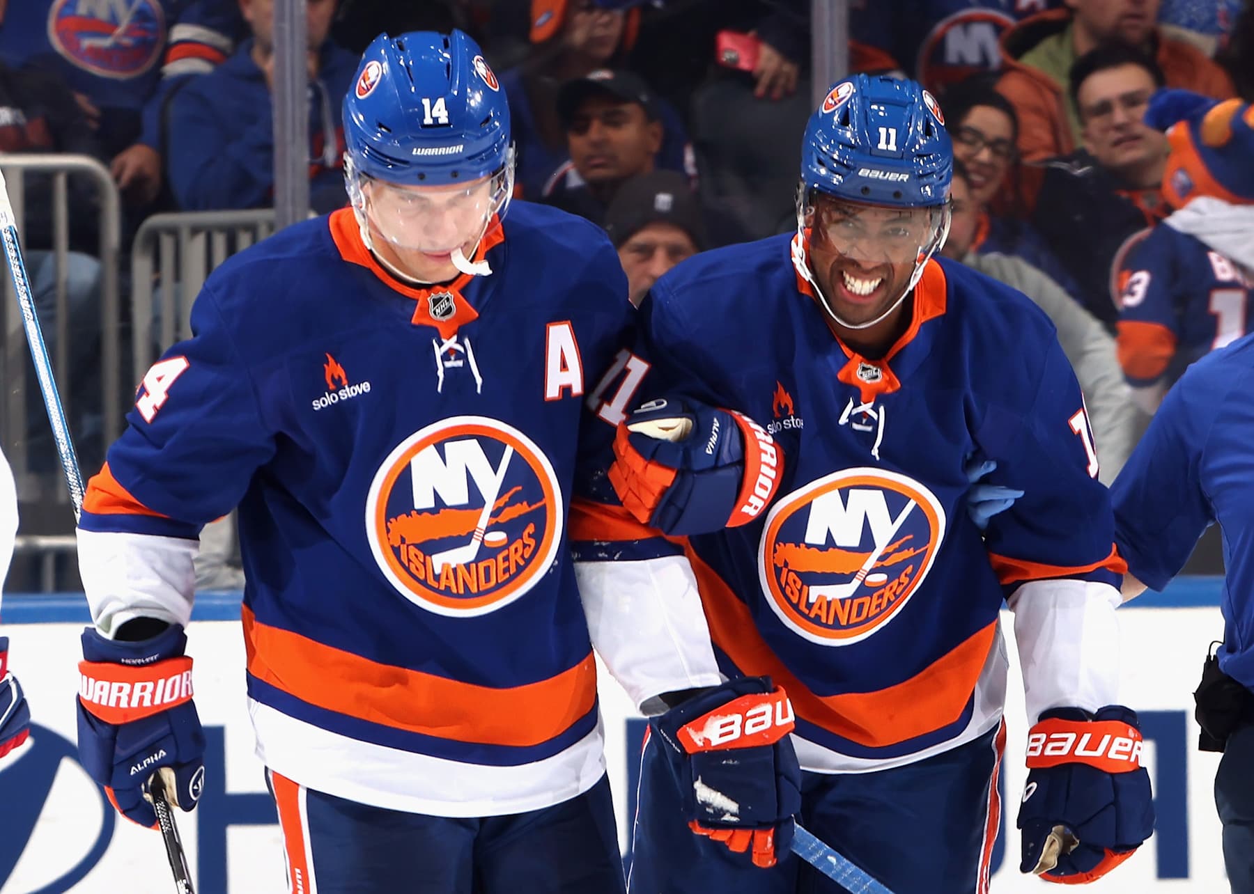 ELMONT, NEW YORK - OCTOBER 19: Bo Horvat #14 of the New York Islanders (L) assists Anthony Duclair #11 off the ice following a third period injury against the Montreal Canadiens at UBS Arena on October 19, 2024 in Elmont, New York. (Photo by Bruce Bennett/Getty Images)