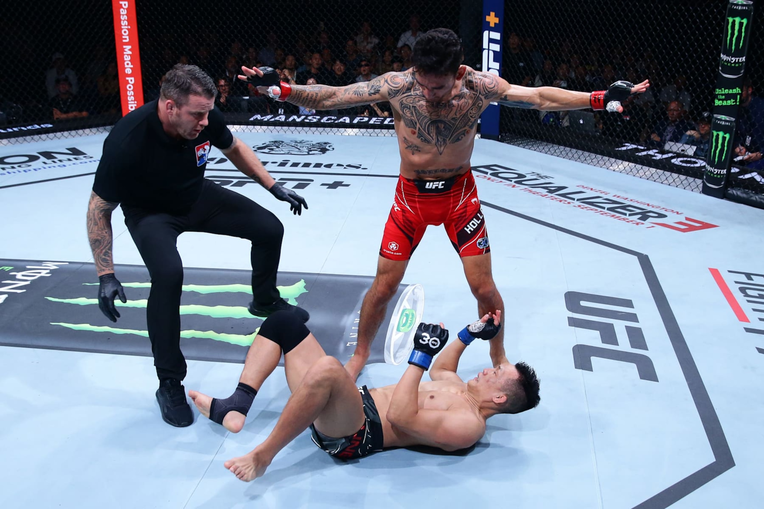 Max Holloway stands over Chan Sung Jung after a knockdown