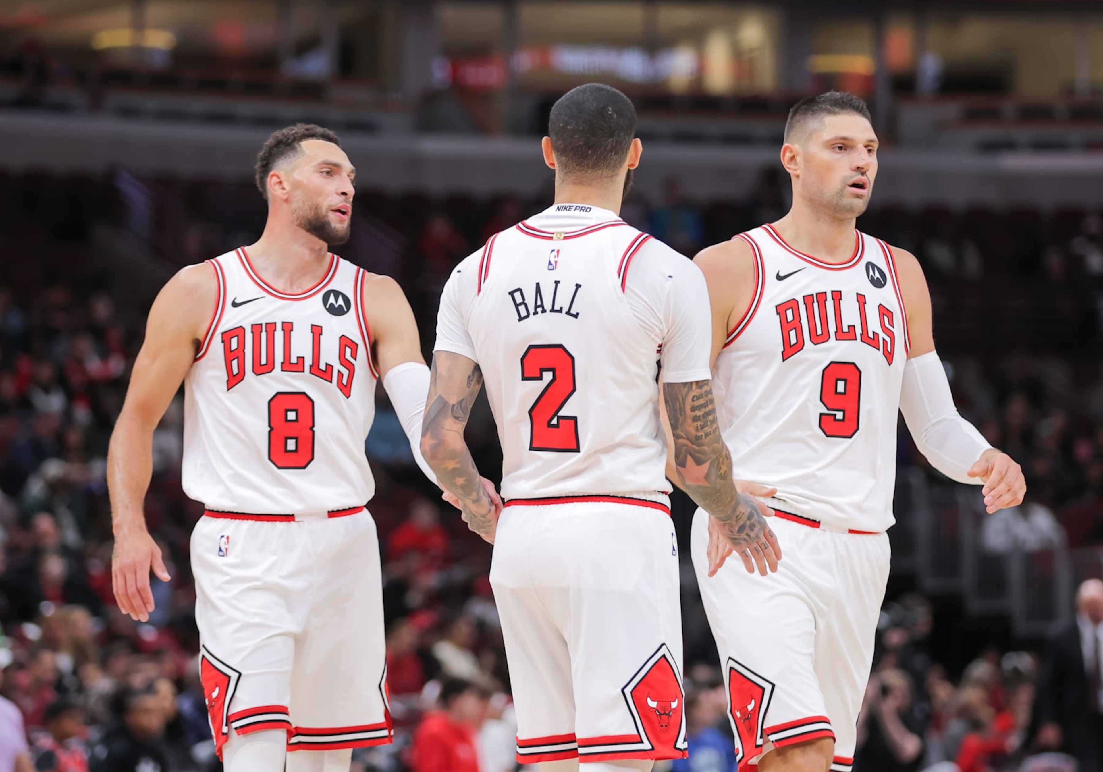 CHICAGO, IL - OCTOBER 16: Chicago Bulls guard Lonzo Ball (2) high vies Chicago Bulls guard Zach LaVine (8) and Chicago Bulls center Nikola Vucevic (9) during the first half of a preseason game on October 16, 2024 at the United Center in Chicago, Illinois. (Photo by Melissa Tamez/Icon Sportswire via Getty Images)