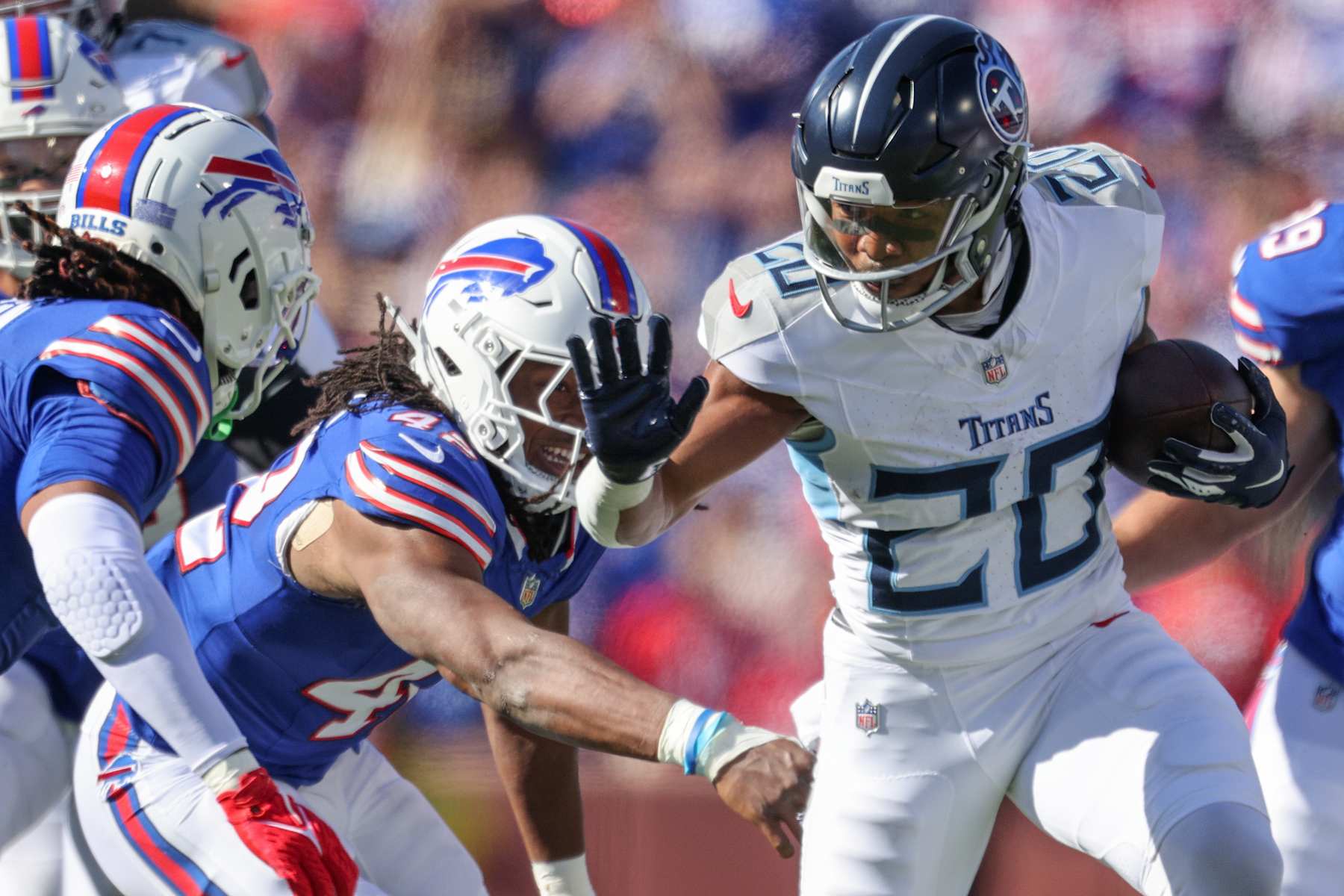 ORCHARD PARK, NEW YORK - OCTOBER 20: Tony Pollard #20 of the Tennessee Titans runs the ball as Dorian Williams #42 of the Buffalo Bills reaches during the first quarter at Highmark Stadium on October 20, 2024 in Orchard Park, New York. (Photo by Bryan Bennett/Getty Images)